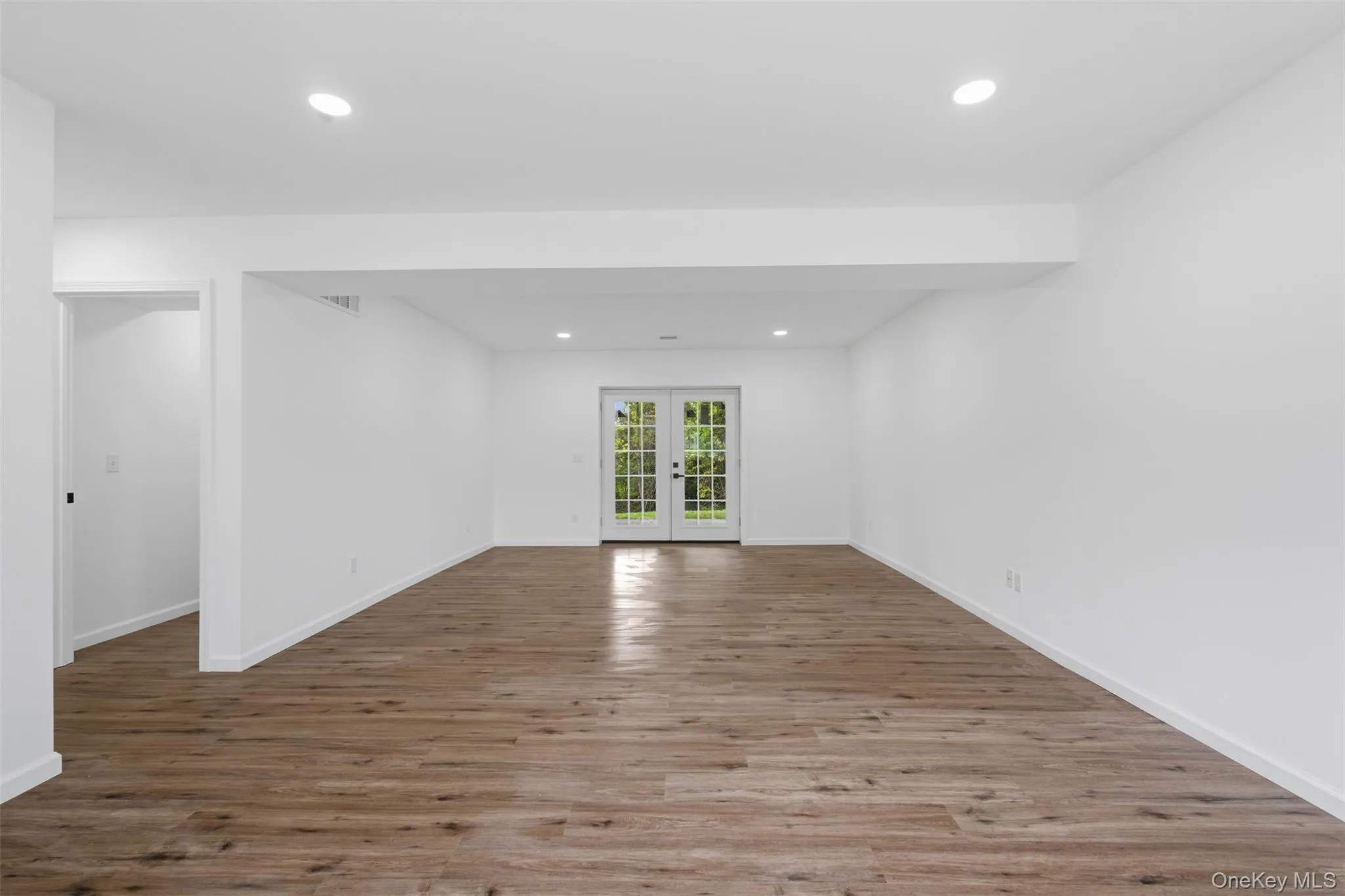Spacious open room with double French doors providing exterior access Spacious open room with double French doors providing exterior access