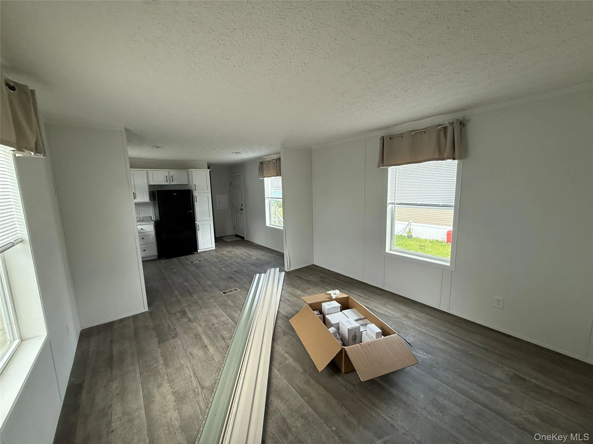 Living room featuring a textured ceiling and dark wood-style flooring Living room featuring a textured ceiling and dark wood-style flooring