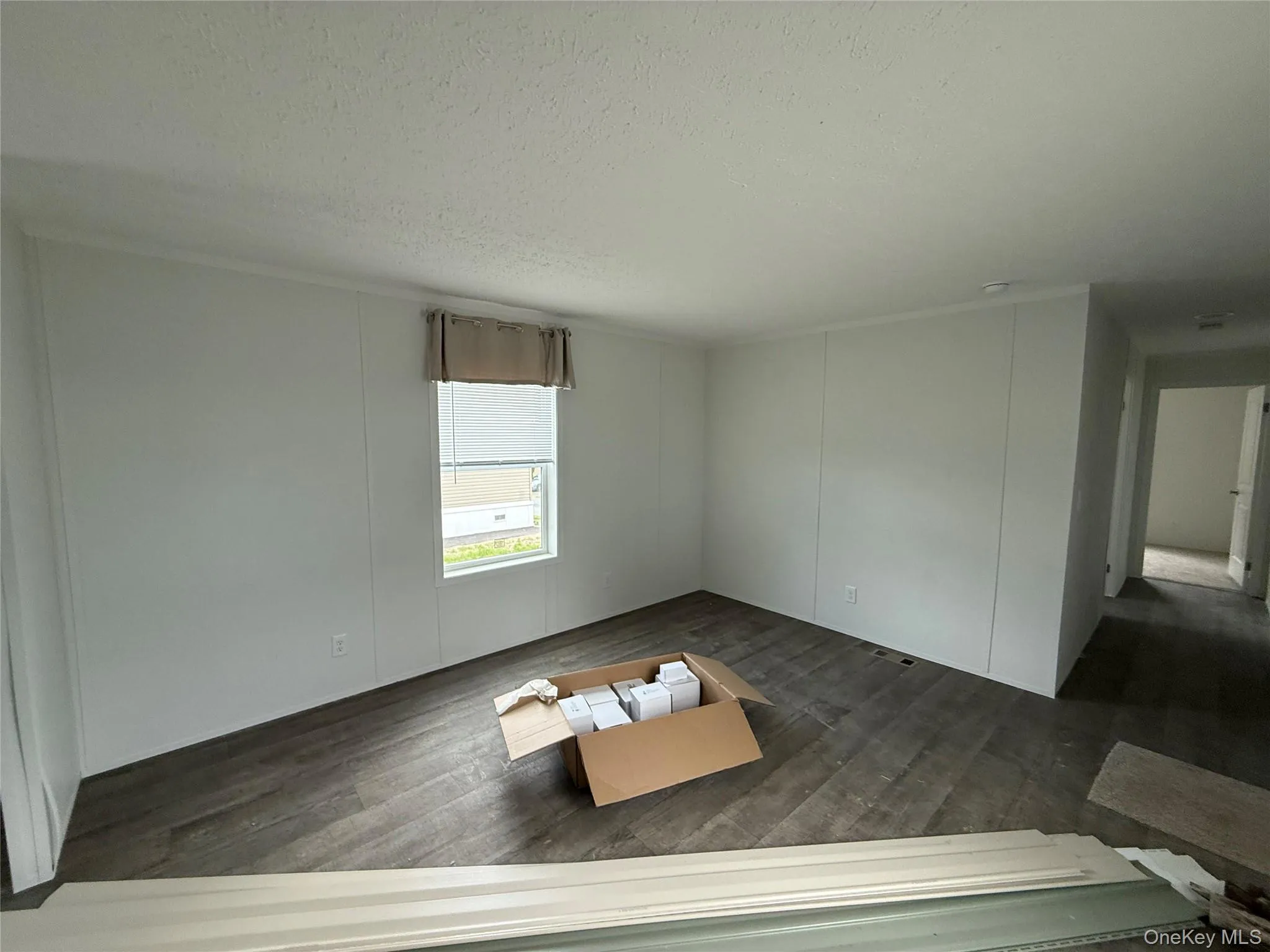 Spare room featuring a textured ceiling and dark wood finished floors Spare room featuring a textured ceiling and dark wood finished floors