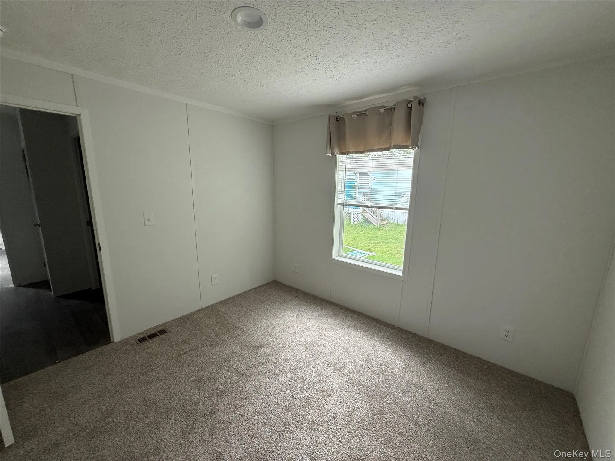 Spare room featuring a textured ceiling and carpet Spare room featuring a textured ceiling and carpet