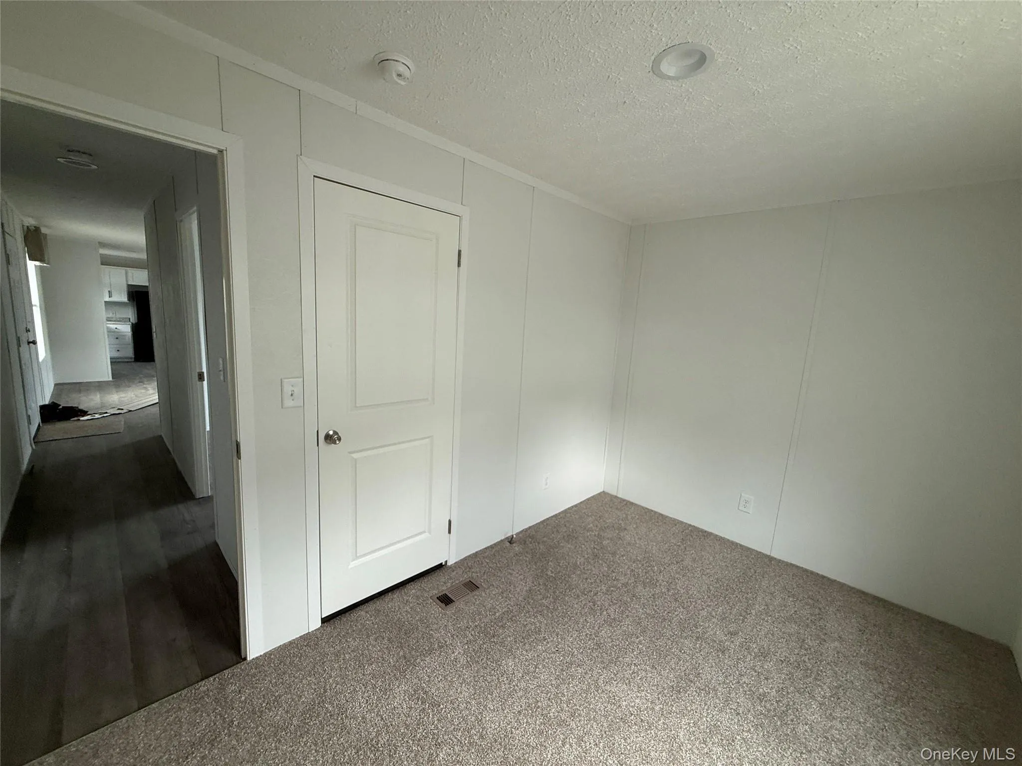 Carpeted empty room with a textured ceiling Carpeted empty room with a textured ceiling