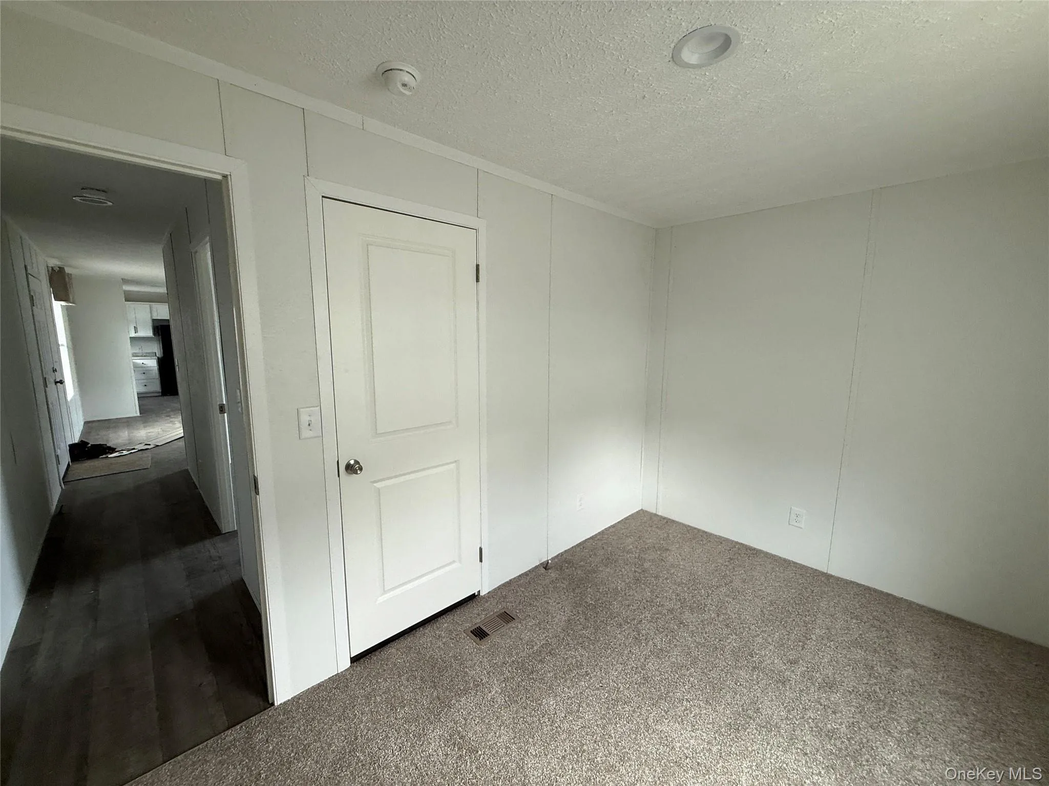 Unfurnished bedroom featuring a textured ceiling and carpet Unfurnished bedroom featuring a textured ceiling and carpet
