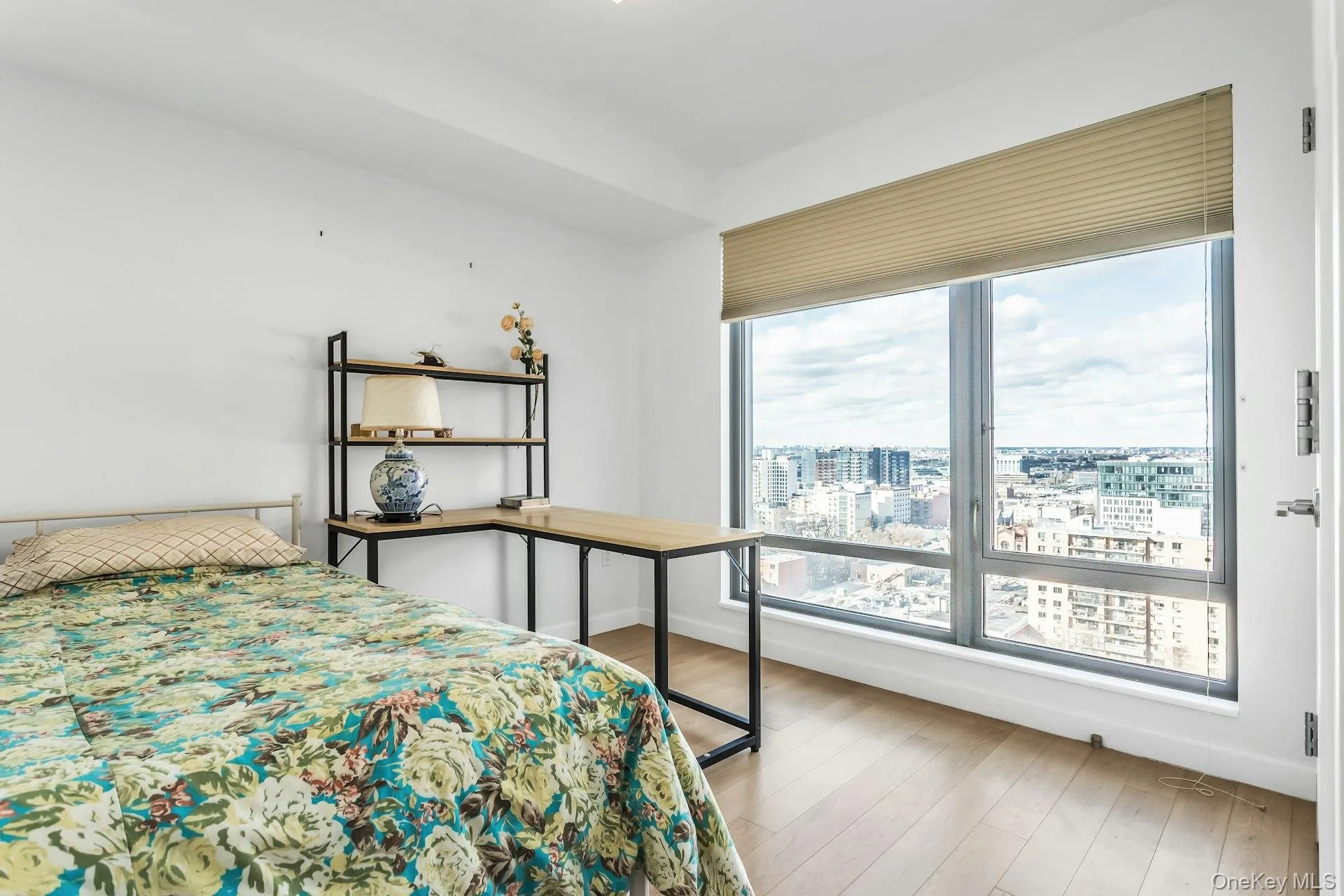 Bedroom featuring light wood-style floors and a view of city Bedroom featuring light wood-style floors and a view of city