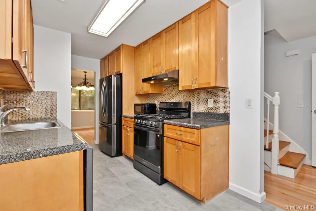 Alternate view of kitchen with entry to the right and view of dining rear Alternate view of kitchen with entry to the right and view of dining rear