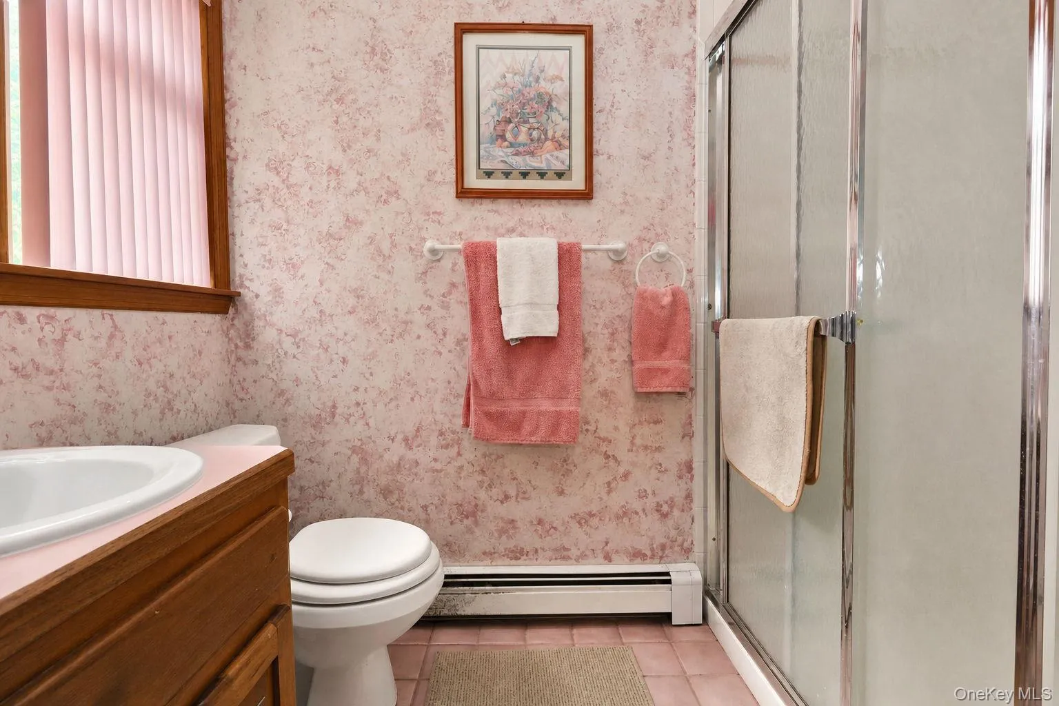 Bathroom featuring wood-finish vanity, integrated sink, and glass door walk in shower enclosure Bathroom featuring wood-finish vanity, integrated sink, and glass door walk in shower enclosure