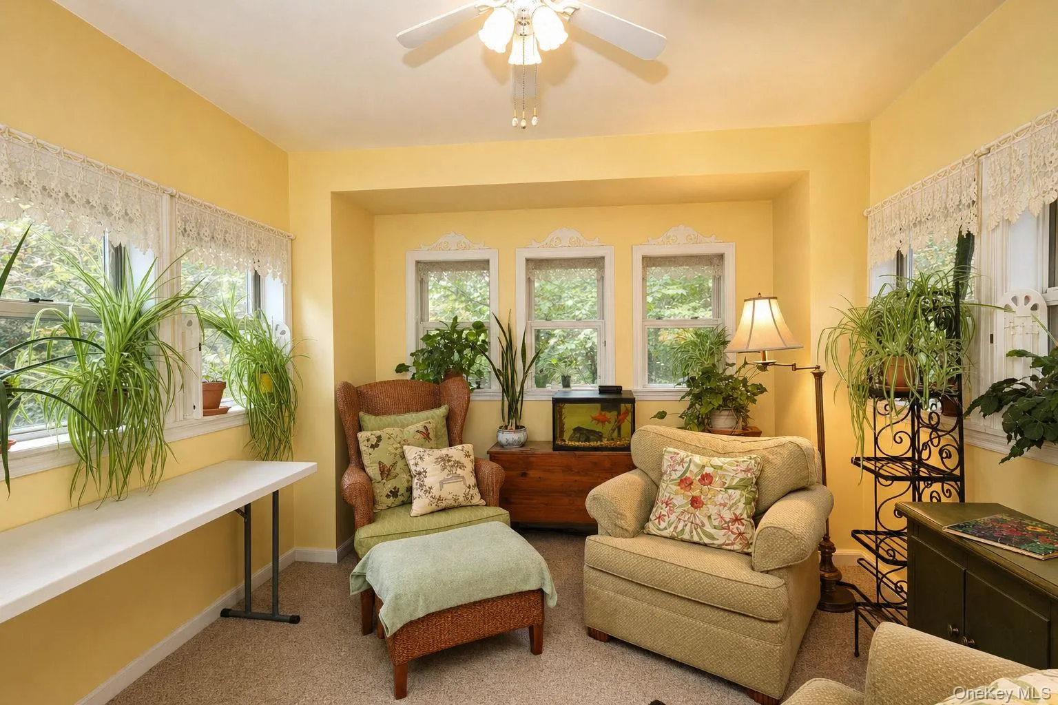 Garden room with recessed wall detail, three transom windows, ceiling fan with light fixture, carpeted flooring Garden room with recessed wall detail, three transom windows, ceiling fan with light fixture, carpeted flooring