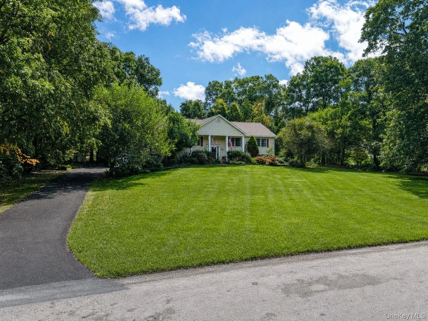 Front of the home with manicured lawn and new paved driveway Front of the home with manicured lawn and new paved driveway