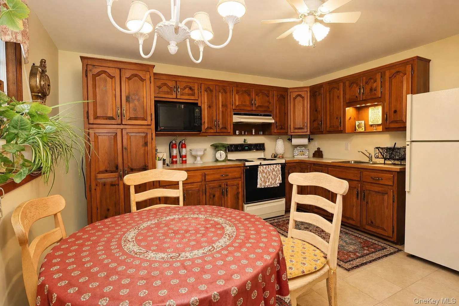 Kitchen featuring wood-finish cabinetry, built-in microwave, and ceiling fan Kitchen featuring wood-finish cabinetry, built-in microwave, and ceiling fan
