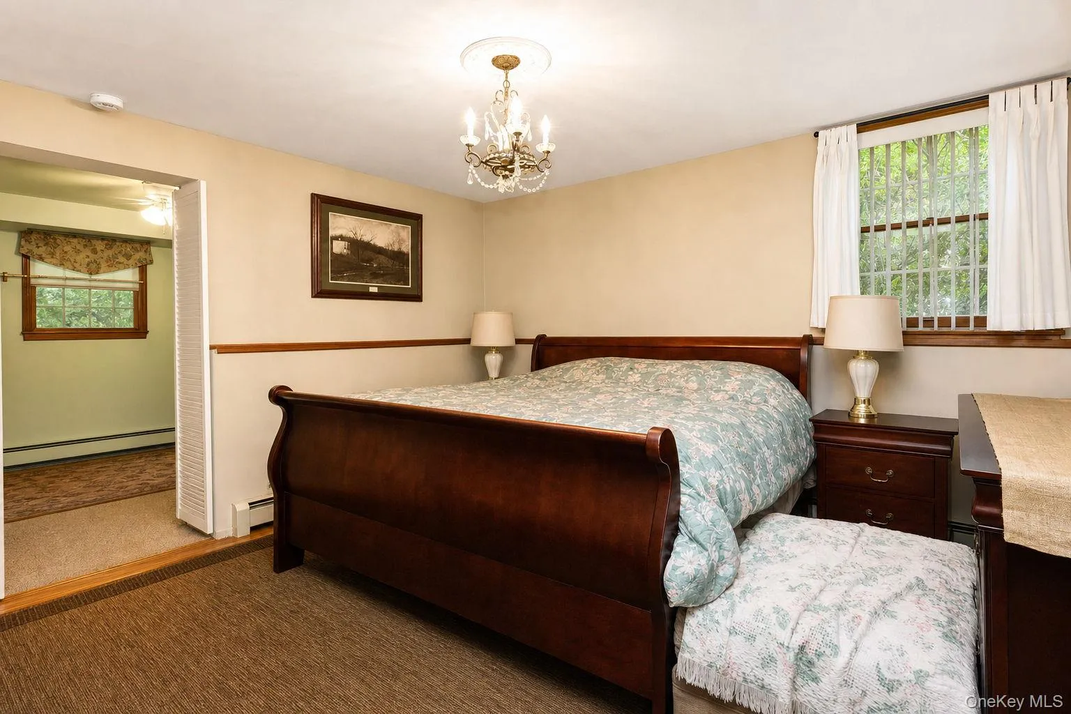 Carpeted flooring, chandelier lighting, wood trim, and a window with blinds Carpeted flooring, chandelier lighting, wood trim, and a window with blinds
