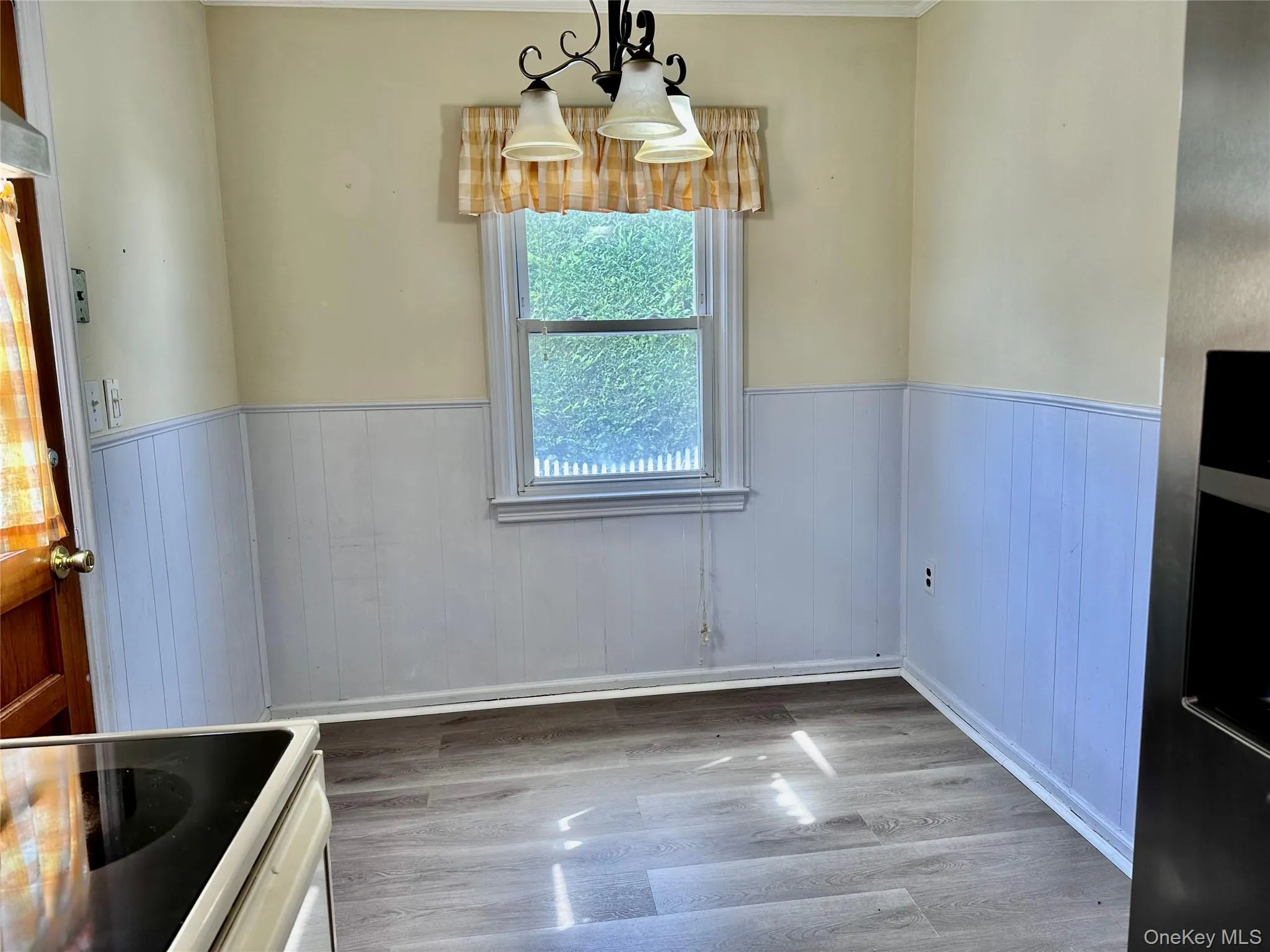 Unfurnished dining area with light wood-type flooring and wainscoting Unfurnished dining area with light wood-type flooring and wainscoting