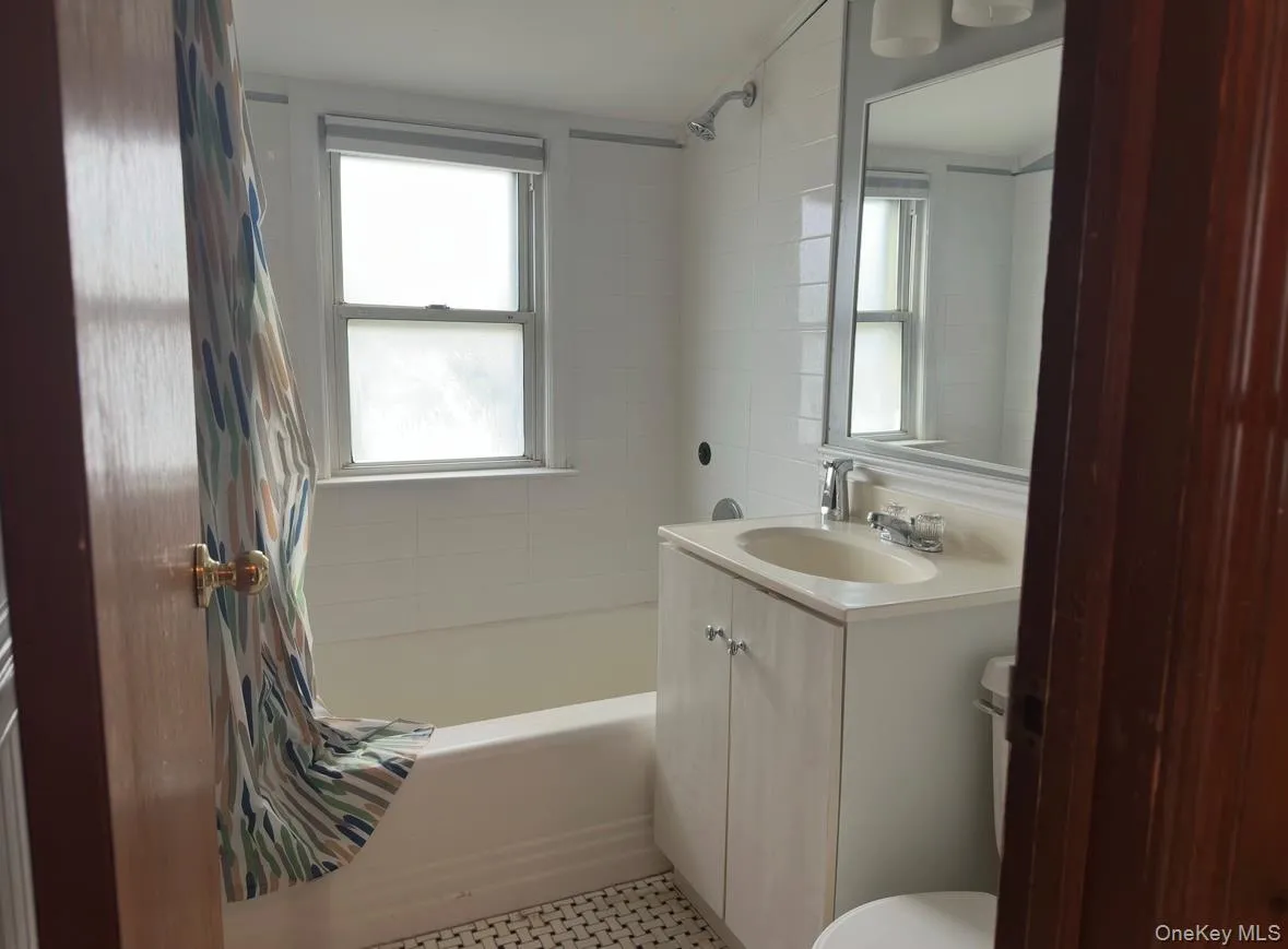 Bathroom featuring shower / tub combo and vanity Bathroom featuring shower / tub combo and vanity