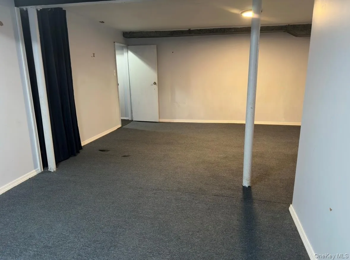 Finished below grade area with dark colored carpet Finished below grade area with dark colored carpet