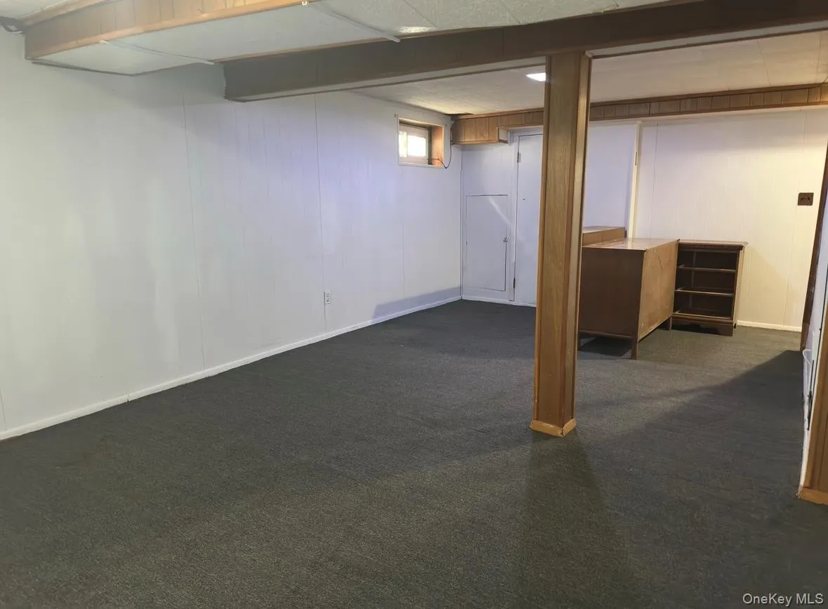 Below grade area with dark colored carpet Below grade area with dark colored carpet