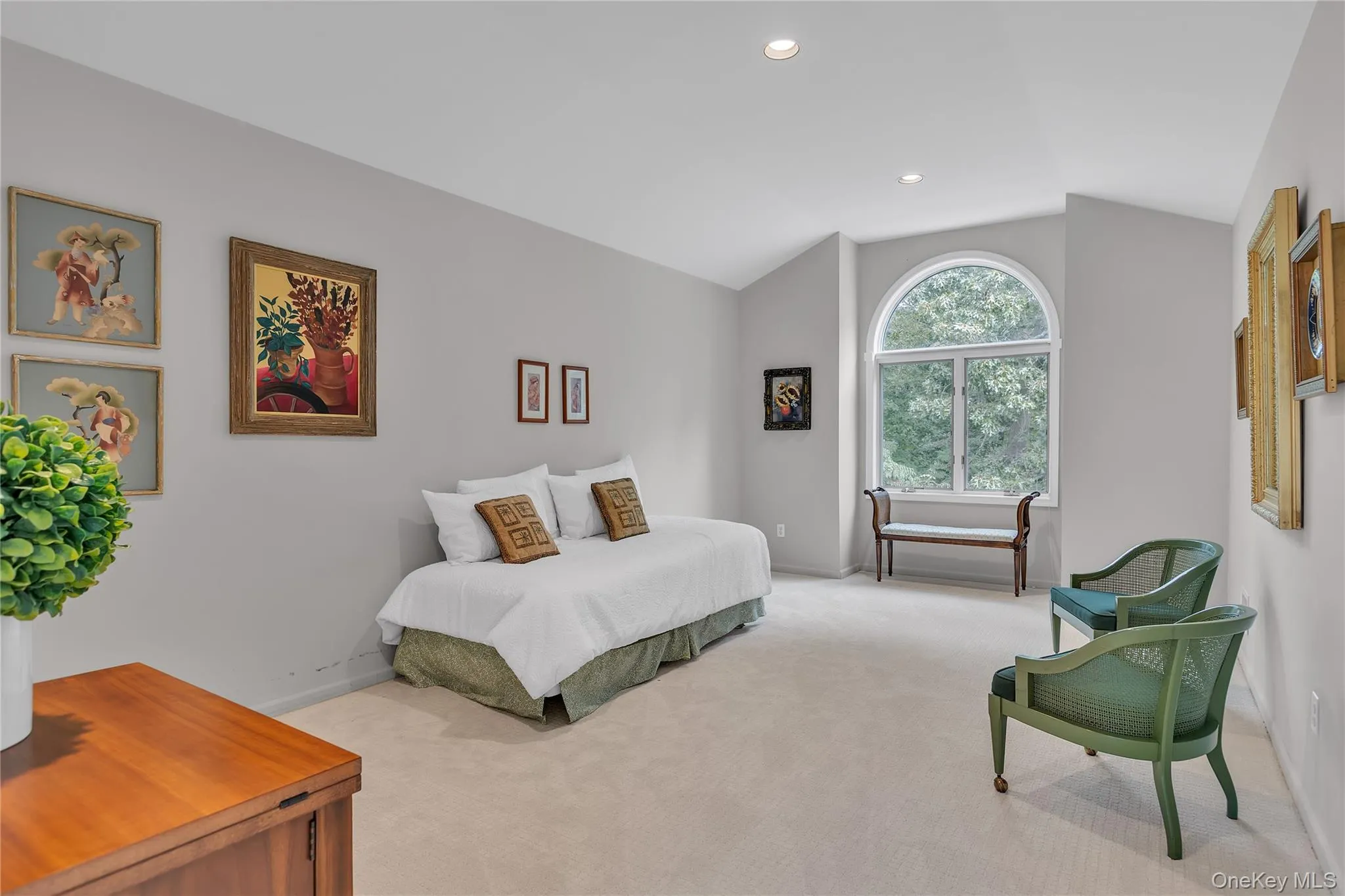 Spacious room featuring a large arched window, vaulted ceiling, recessed lighting, walk in closet and neutral carpet flooring. Spacious room featuring a large arched window, vaulted ceiling, recessed lighting, walk in closet and neutral carpet flooring.