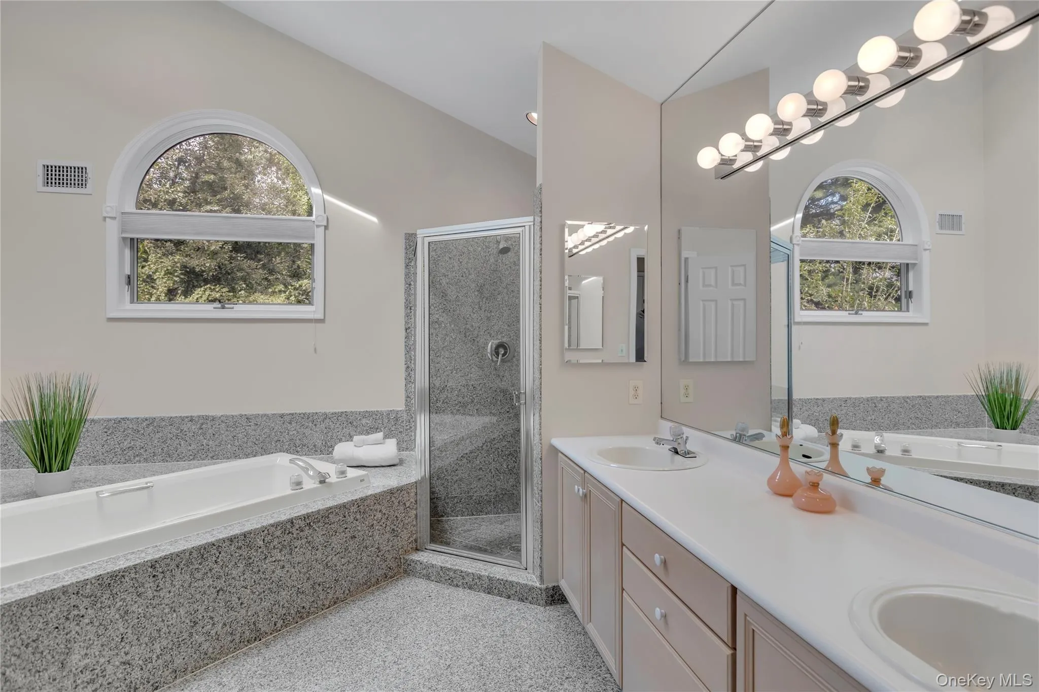 Primary bathroom featuring a built-in tub, separate shower enclosure, and a double vanity with two sinks. Primary bathroom featuring a built-in tub, separate shower enclosure, and a double vanity with two sinks.