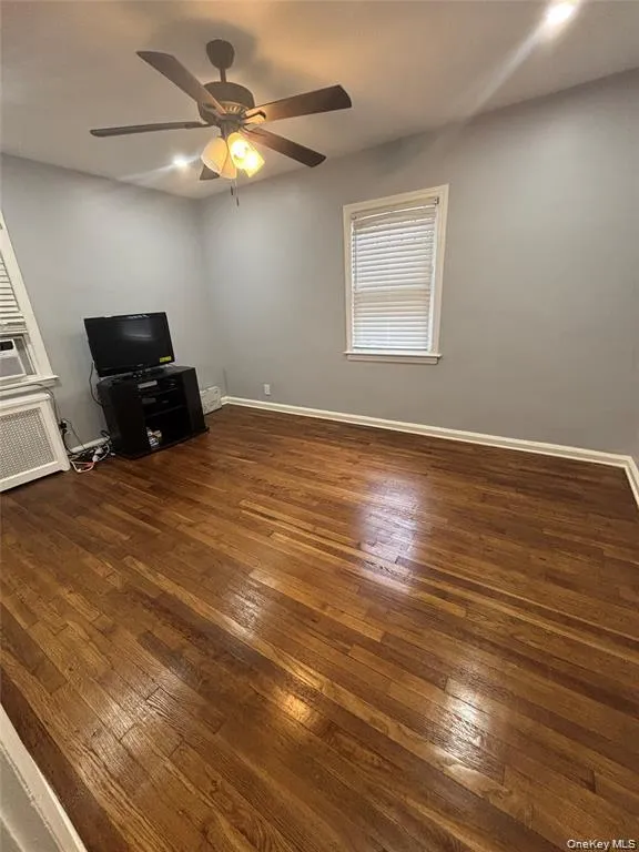 Hardwood flooring, ceiling fan with integrated lighting, and neutral wall tones Hardwood flooring, ceiling fan with integrated lighting, and neutral wall tones