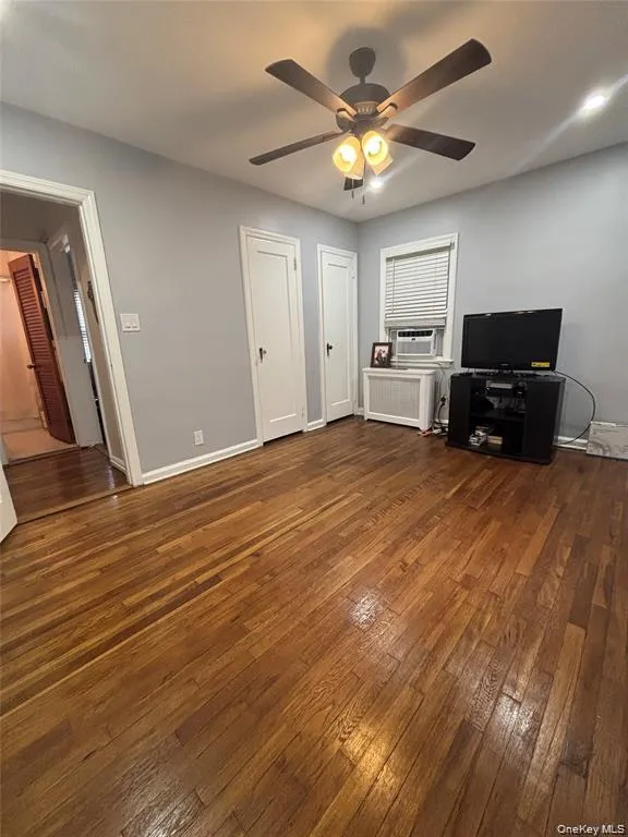 Wood flooring, ceiling fan with integrated lighting, window with blinds, and white doors Wood flooring, ceiling fan with integrated lighting, window with blinds, and white doors