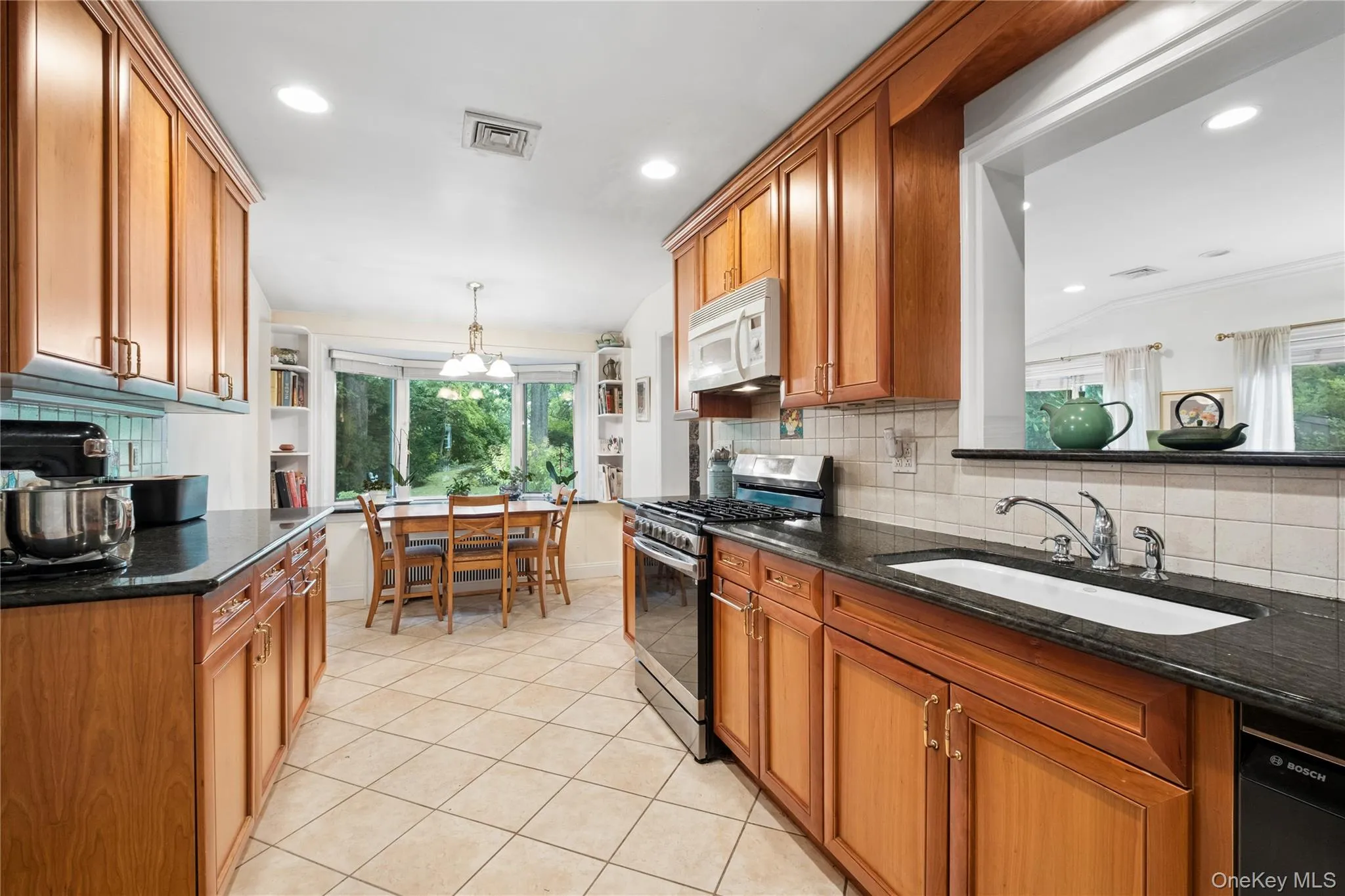 Renovated (2005) kitchen with view of backyard. Wood Cabinets and granite countertops Renovated (2005) kitchen with view of backyard. Wood Cabinets and granite countertops