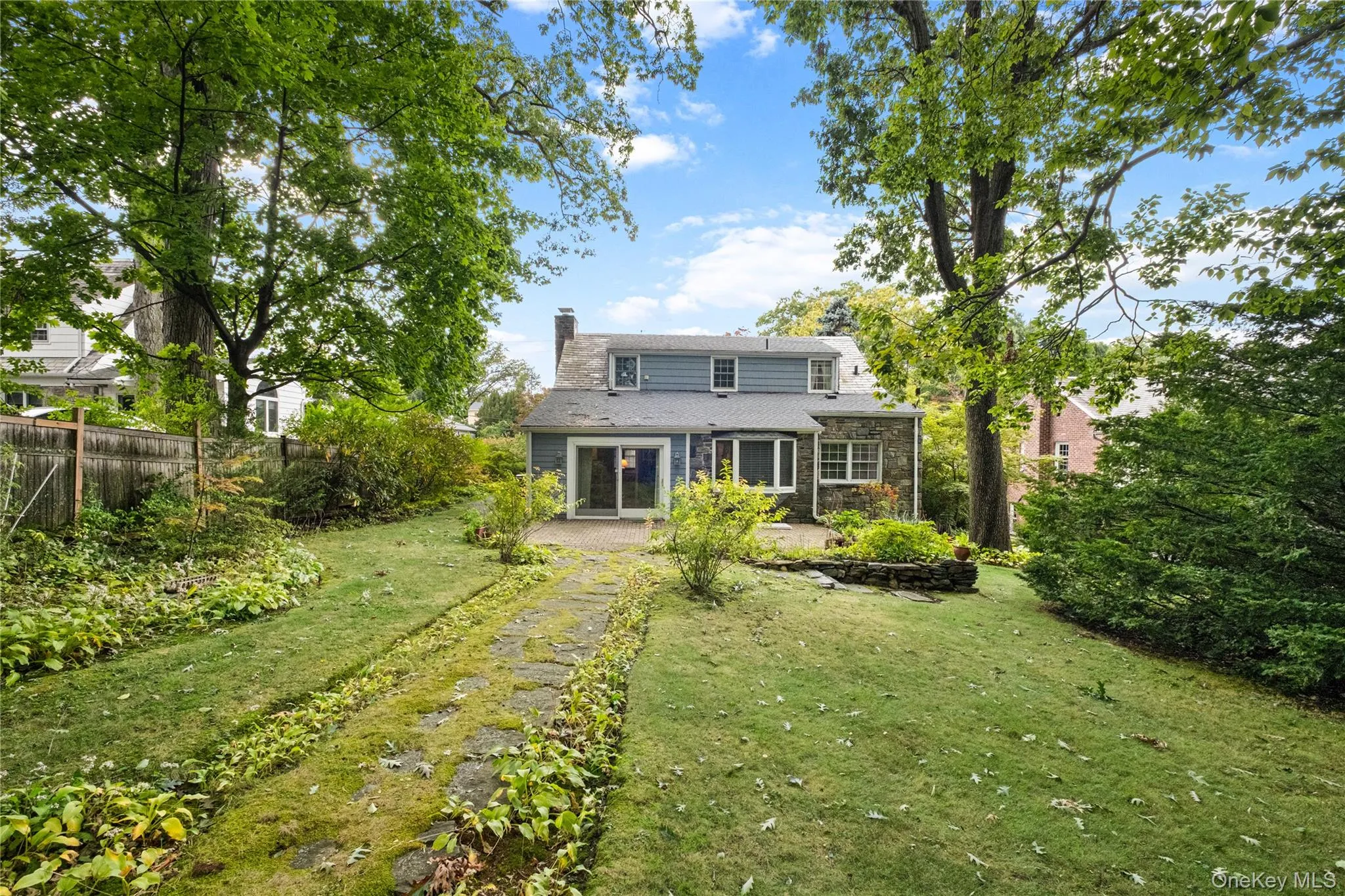 Back of home with patio and large grassy yard Back of home with patio and large grassy yard
