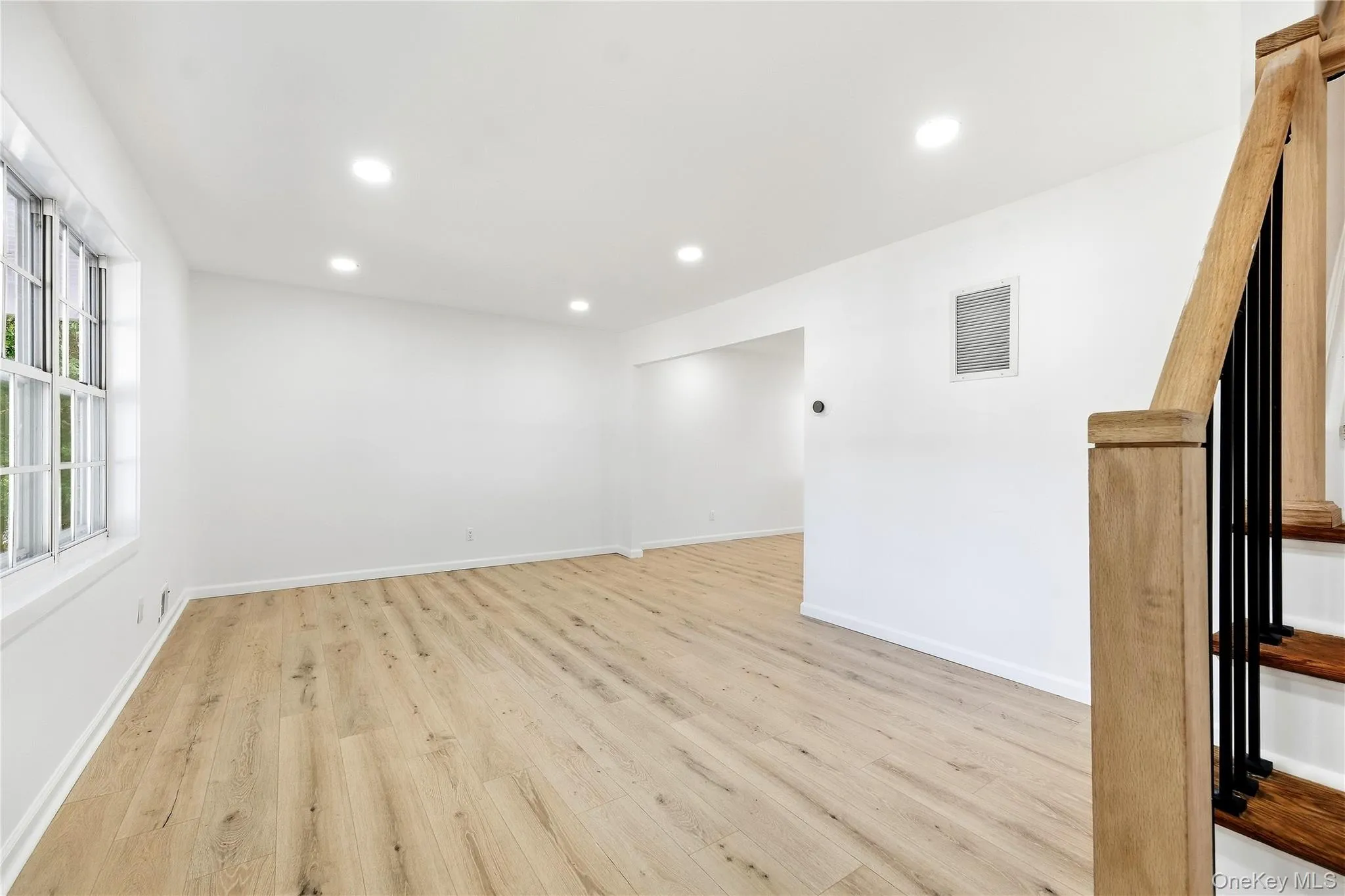 Wood-finish flooring throughout, recessed lighting, and a window with natural light Wood-finish flooring throughout, recessed lighting, and a window with natural light