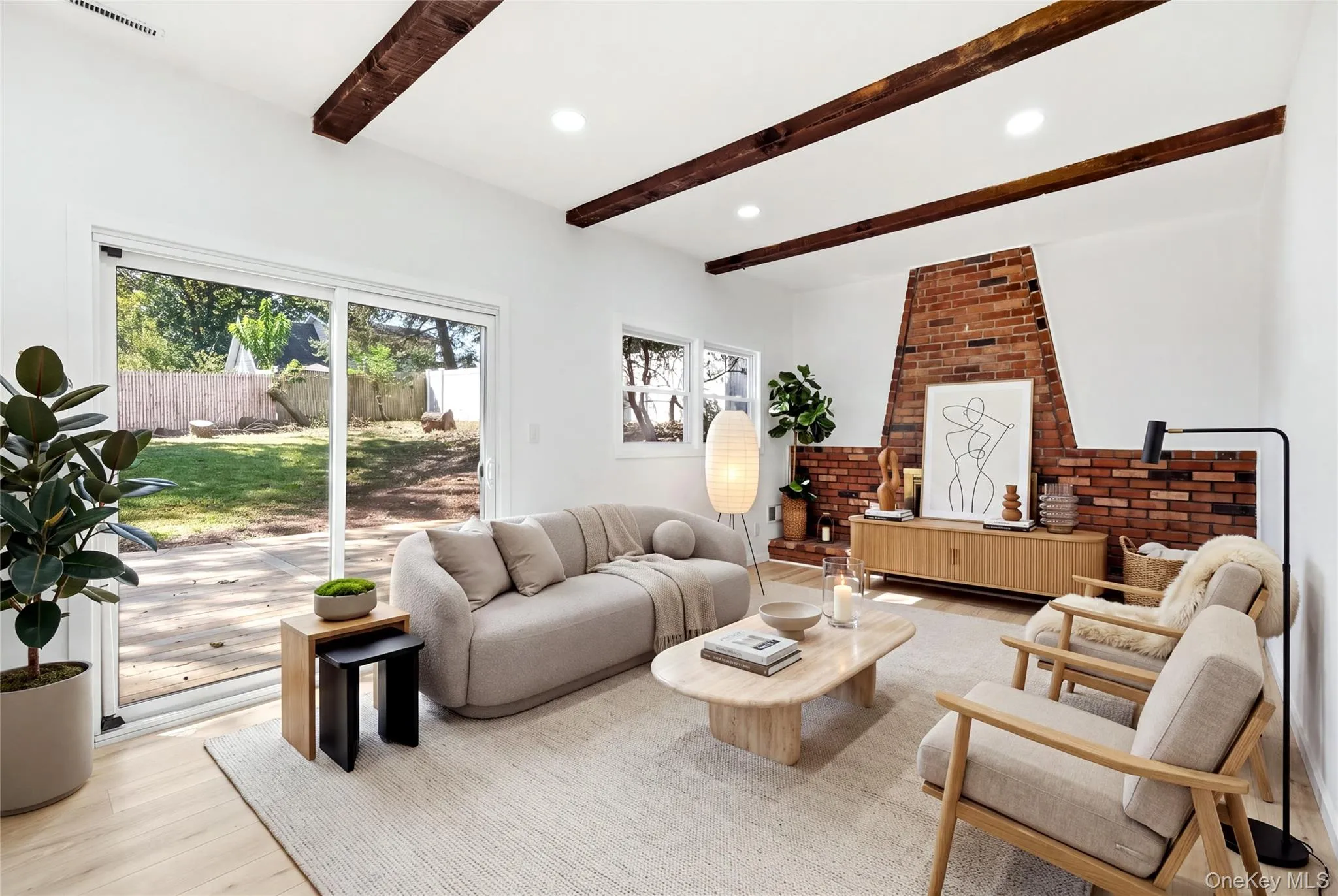 Virtually staged. Exposed ceiling beams, brick fireplace, wood-finish flooring, recessed lighting, and sliding glass door to yard Virtually staged. Exposed ceiling beams, brick fireplace, wood-finish flooring, recessed lighting, and sliding glass door to yard