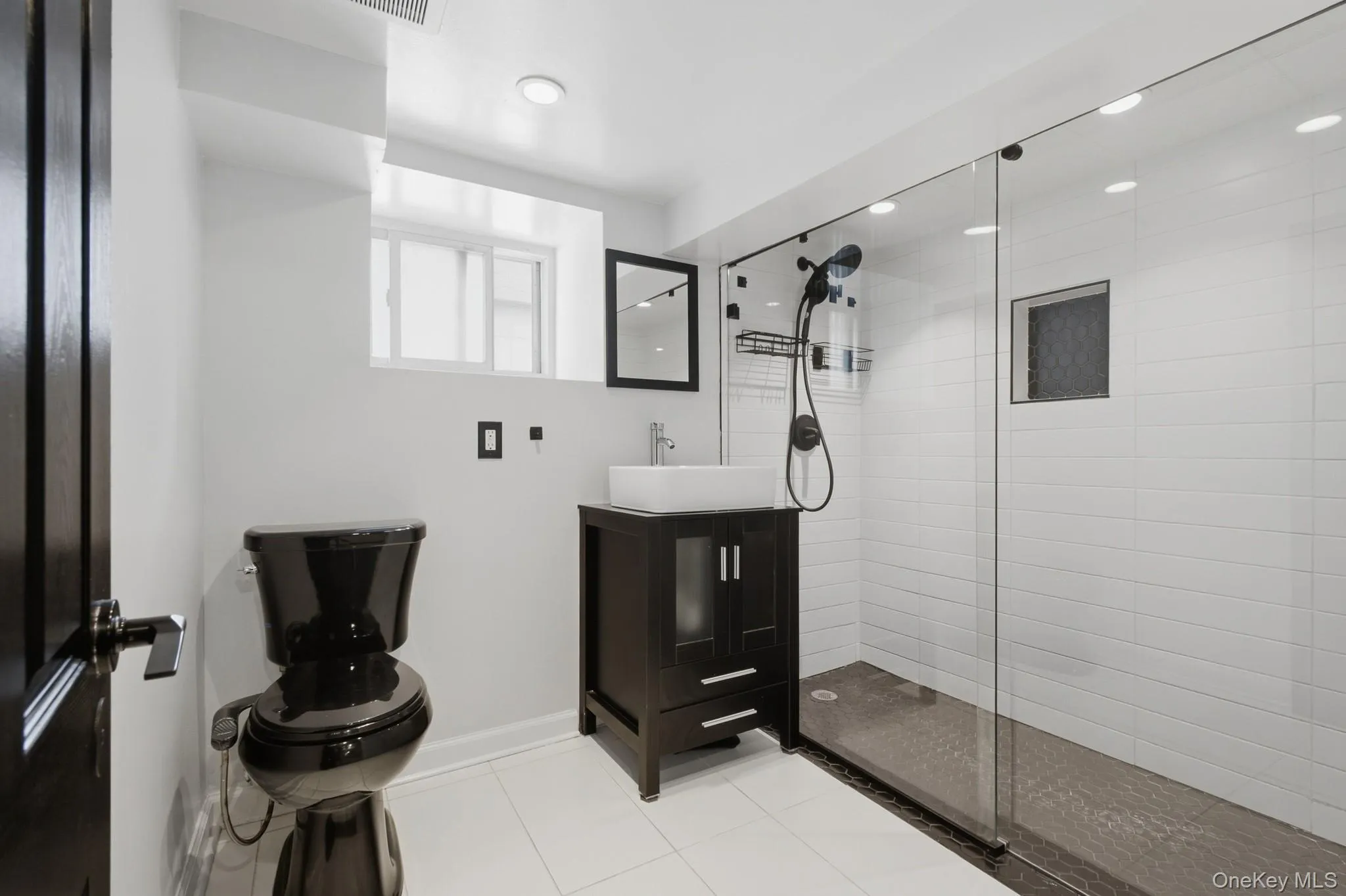 Walk-in shower with clear glass enclosure and white subway tile surround Walk-in shower with clear glass enclosure and white subway tile surround
