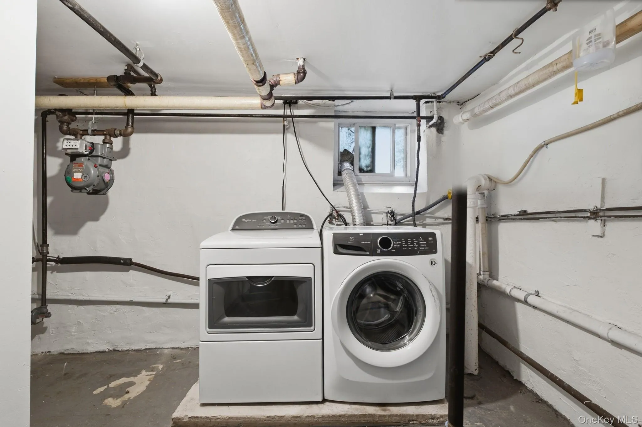 Dedicated laundry area featuring a front-load washing machine and a top-load dryer Dedicated laundry area featuring a front-load washing machine and a top-load dryer