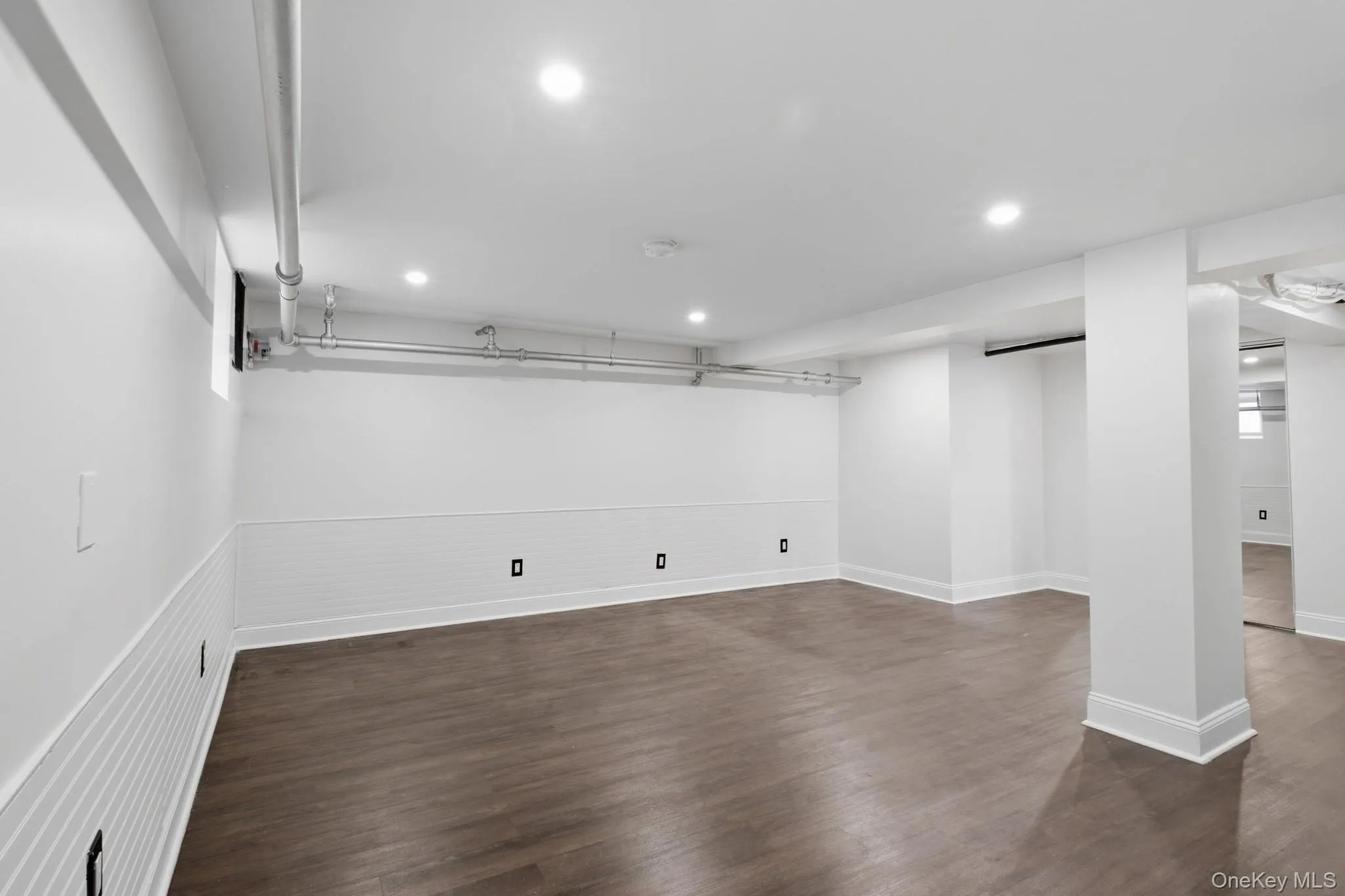 Recessed lighting, wood-finish flooring, white walls, white ceiling, white wainscoting Recessed lighting, wood-finish flooring, white walls, white ceiling, white wainscoting