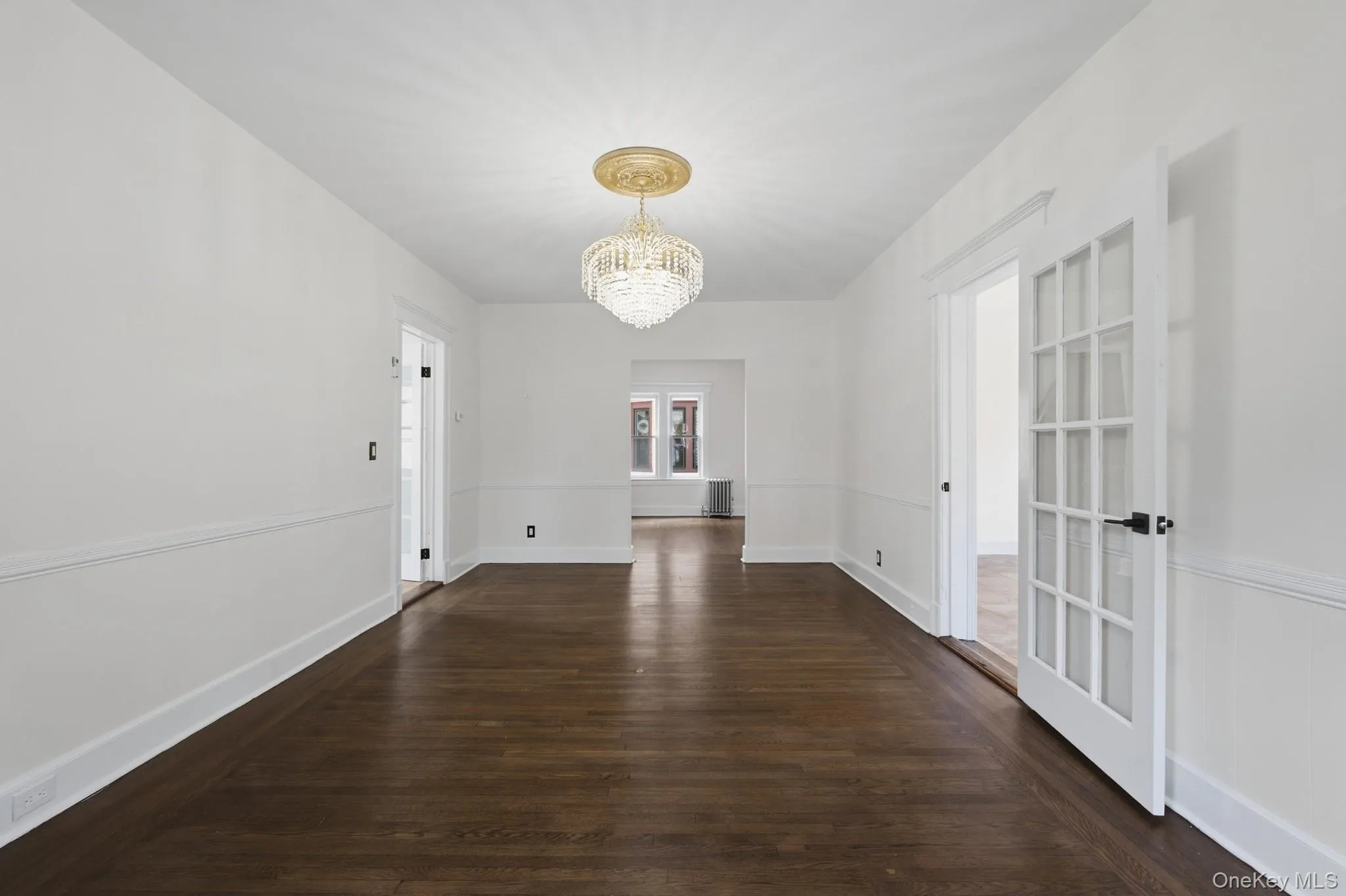 Hardwood flooring, crystal chandelier, architectural molding, French doors with glass panes, and solid panel doors Hardwood flooring, crystal chandelier, architectural molding, French doors with glass panes, and solid panel doors