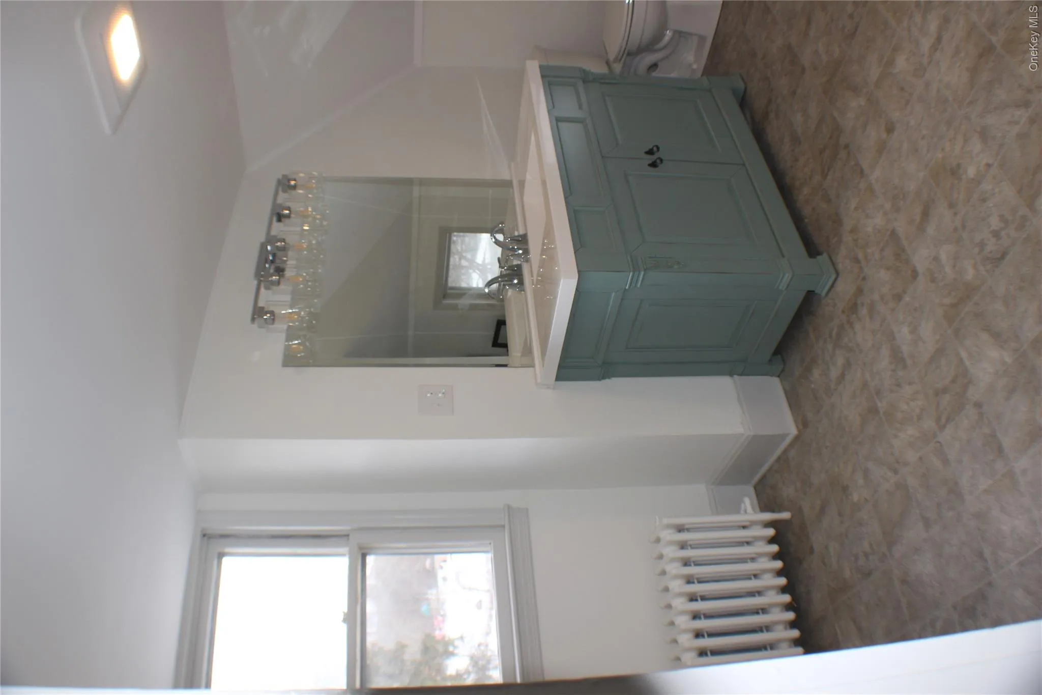 Bathroom featuring vanity, radiator, and plenty of natural light Bathroom featuring vanity, radiator, and plenty of natural light