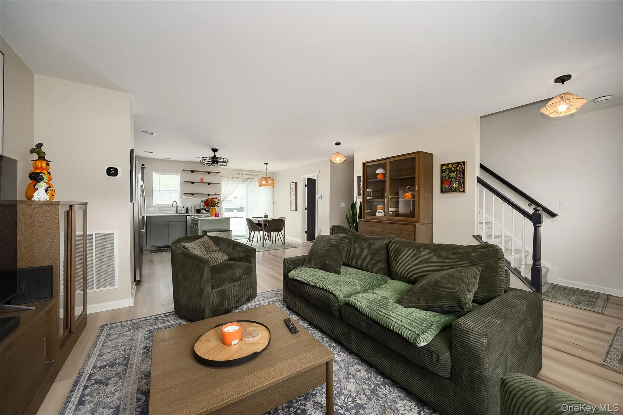 Open-concept living area with vinyl plank flooring, a built-in staircase, and recessed lighting Open-concept living area with vinyl plank flooring, a built-in staircase, and recessed lighting
