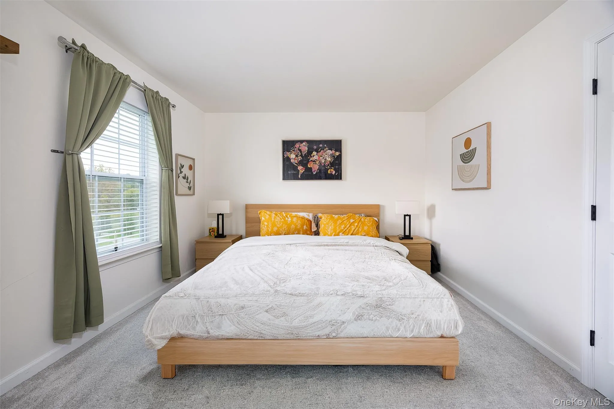 Expansive room with neutral carpeting, white walls, and a large window with blinds Expansive room with neutral carpeting, white walls, and a large window with blinds