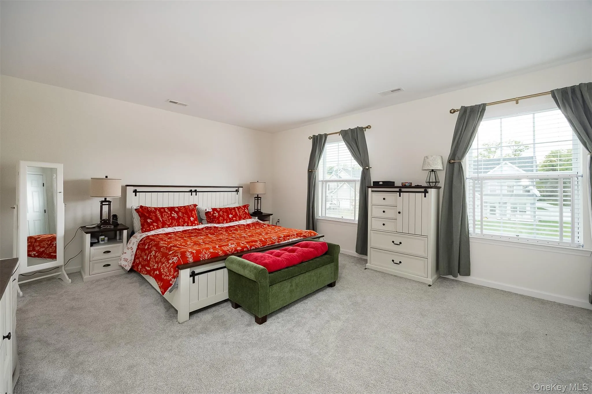 Expansive room featuring light-colored carpeting, multiple windows with blinds Expansive room featuring light-colored carpeting, multiple windows with blinds