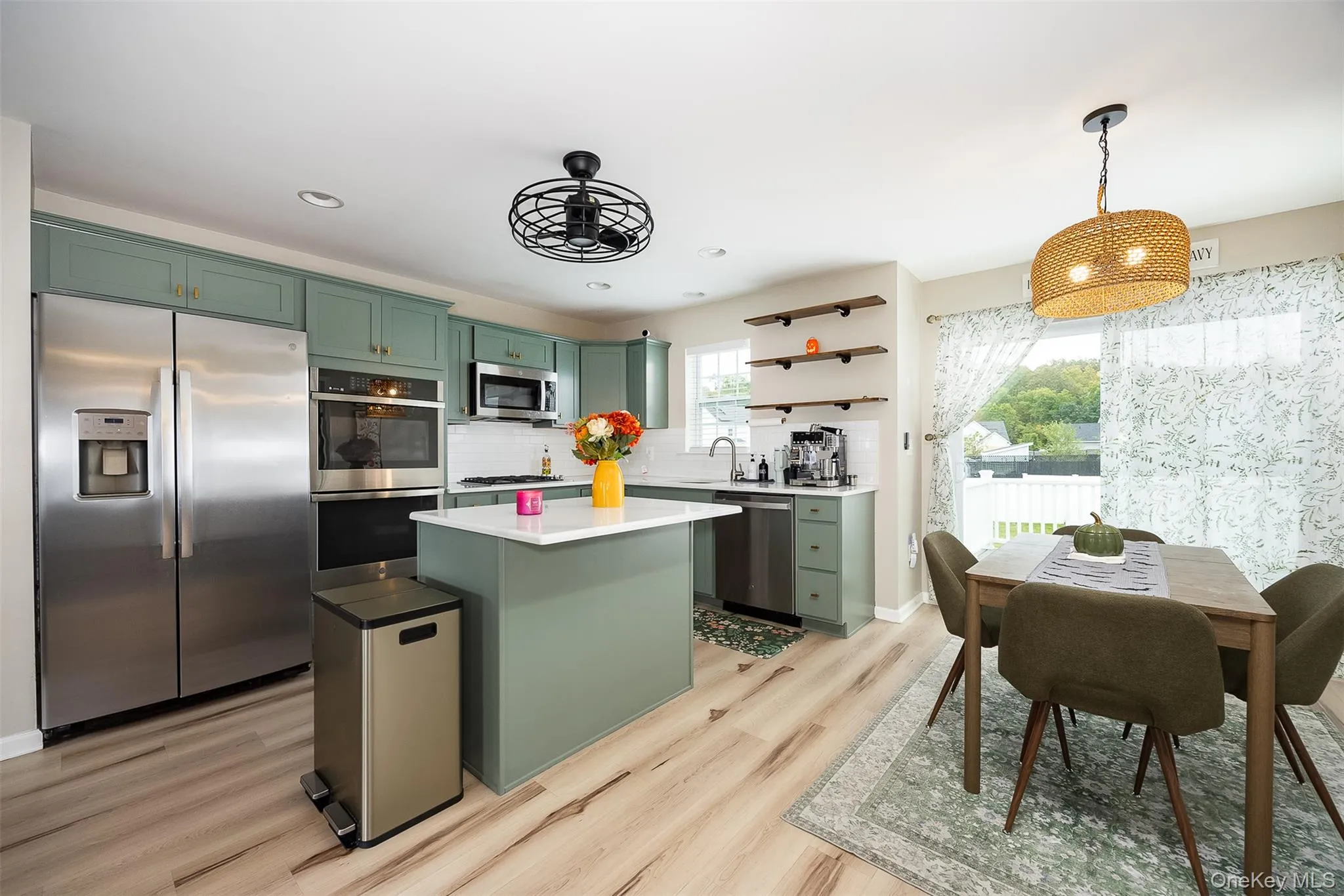 Light vinyl plank flooring, recessed lighting, and a sliding glass door Light vinyl plank flooring, recessed lighting, and a sliding glass door