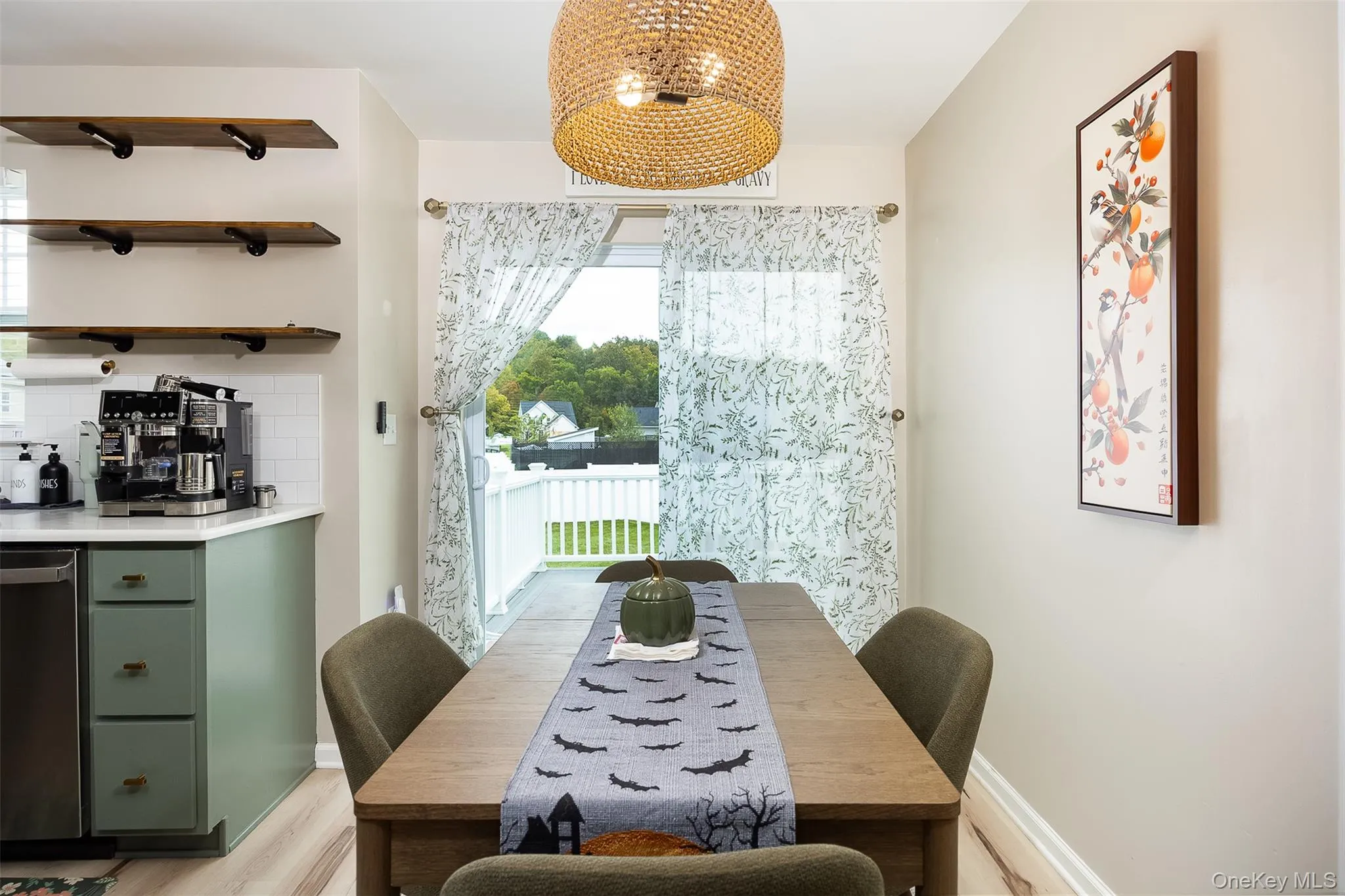 Vinyl plank flooring, light green cabinetry, white subway tile backsplash, white countertops, and a full-light patio door Vinyl plank flooring, light green cabinetry, white subway tile backsplash, white countertops, and a full-light patio door