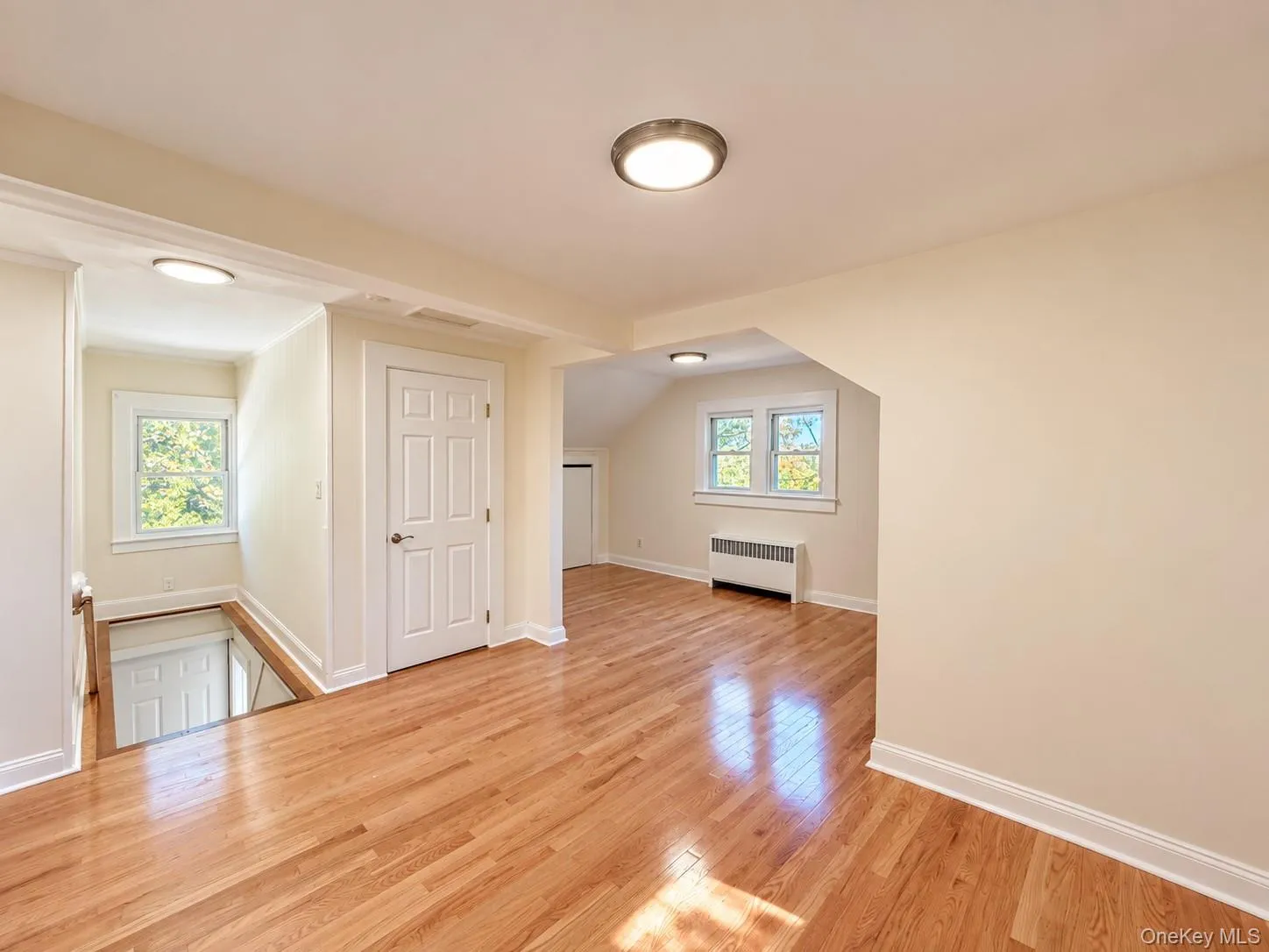 Hardwood flooring, recessed lighting, neutral wall tones, white trim, and white paneled doors Hardwood flooring, recessed lighting, neutral wall tones, white trim, and white paneled doors