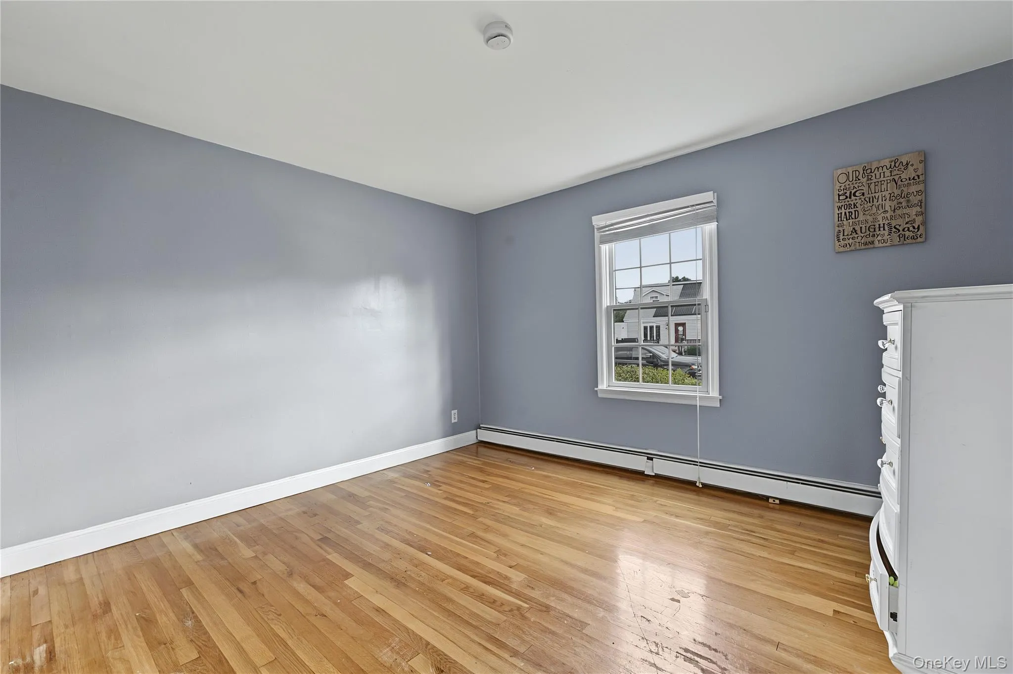 First floor bedroom Hardwood flooring, single window, baseboard heating, white trim and closet First floor bedroom Hardwood flooring, single window, baseboard heating, white trim and closet