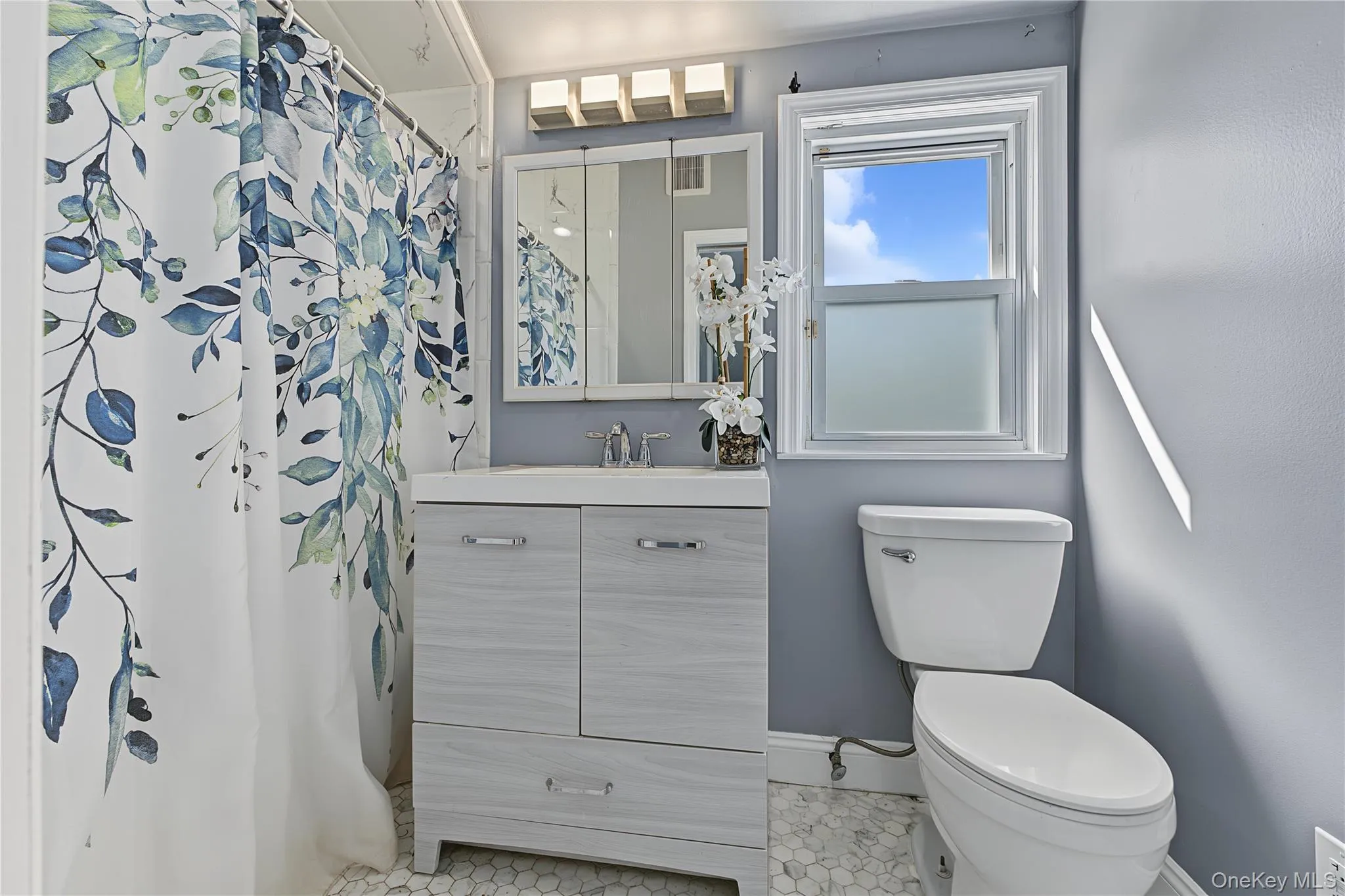 Second floor Bathroom featuring a single-sink vanity with cabinet storage, hexagon-patterned floor tiling, and a window Second floor Bathroom featuring a single-sink vanity with cabinet storage, hexagon-patterned floor tiling, and a window