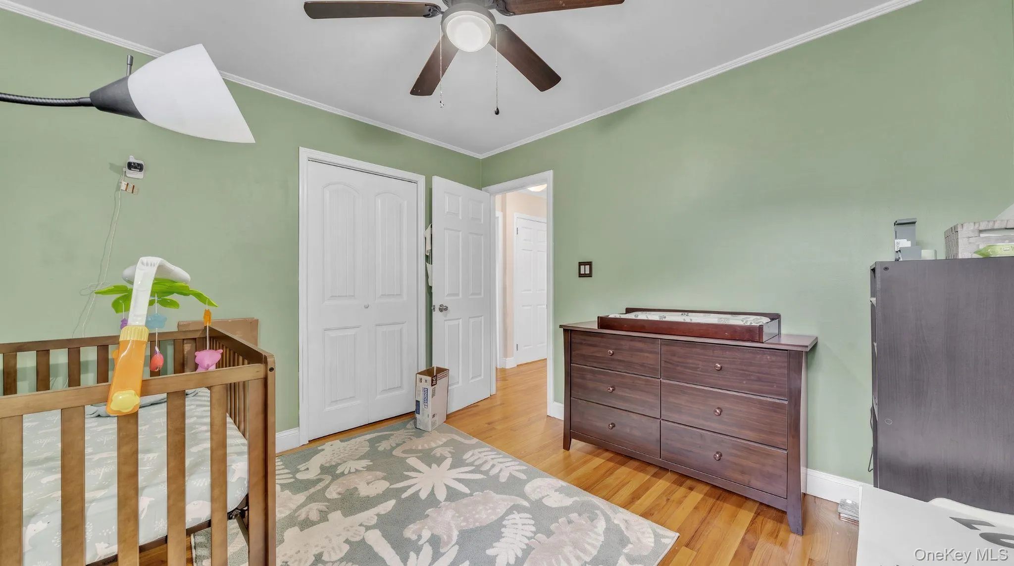 Wood-finish flooring, ceiling fan, white bi-fold closet doors, and white trim Wood-finish flooring, ceiling fan, white bi-fold closet doors, and white trim