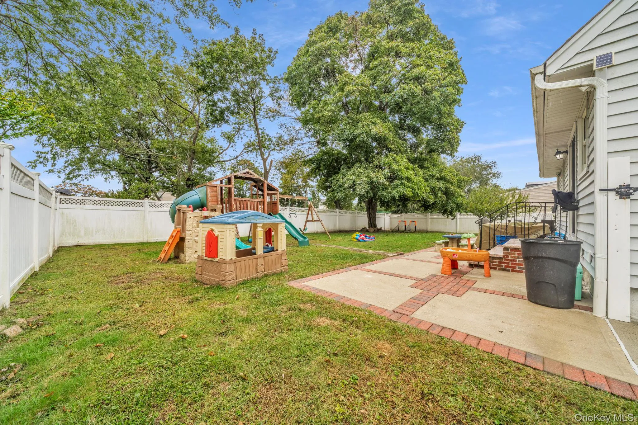 Outdoor patio with brick accents and a fenced yard Outdoor patio with brick accents and a fenced yard