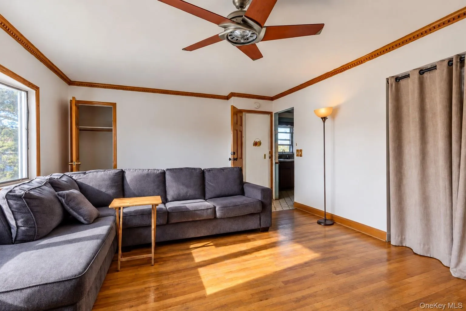 Wood-finish flooring, crown molding, and ceiling fan with integrated light fixture Wood-finish flooring, crown molding, and ceiling fan with integrated light fixture