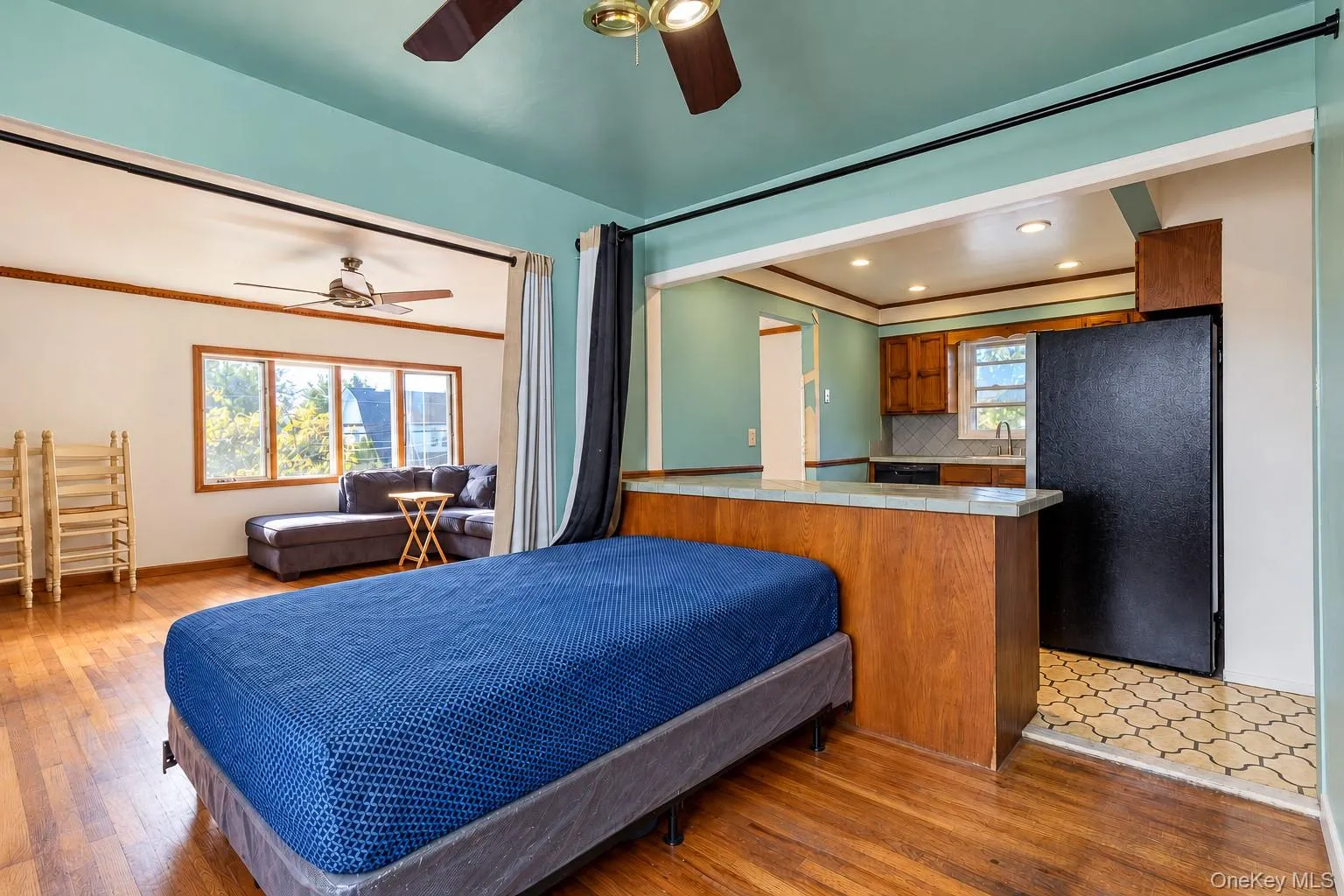 Wood-finish flooring, kitchen featuring a wooden peninsula with a tile countertop, recessed lighting, and a ceiling fan Wood-finish flooring, kitchen featuring a wooden peninsula with a tile countertop, recessed lighting, and a ceiling fan
