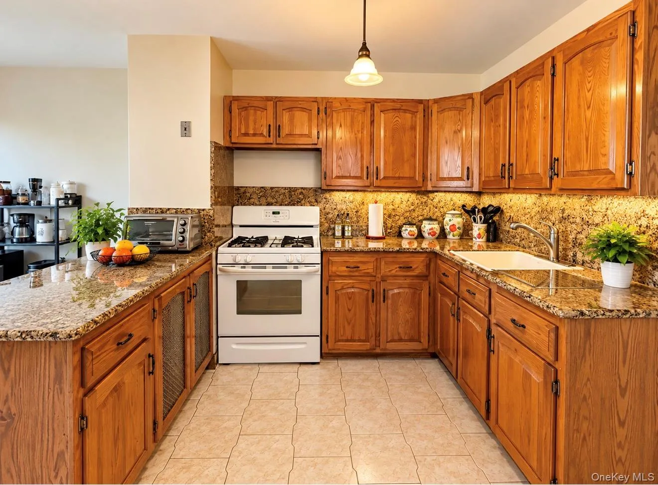 Hardwood cabinetry, stone-finish countertops, tile flooring, and integrated white appliances Hardwood cabinetry, stone-finish countertops, tile flooring, and integrated white appliances