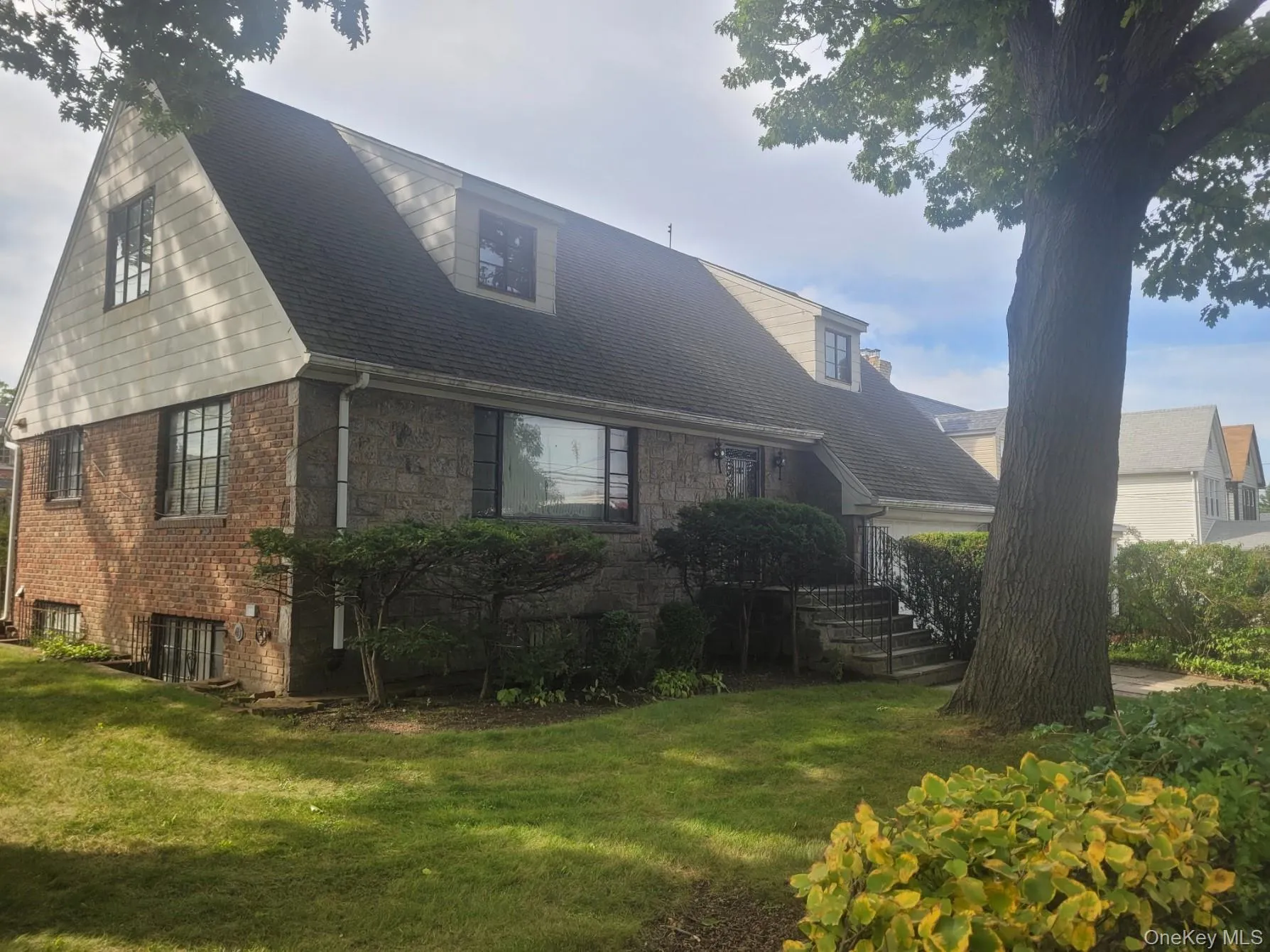 Brick and shingle exterior with a gabled roofline and dormer windows Brick and shingle exterior with a gabled roofline and dormer windows