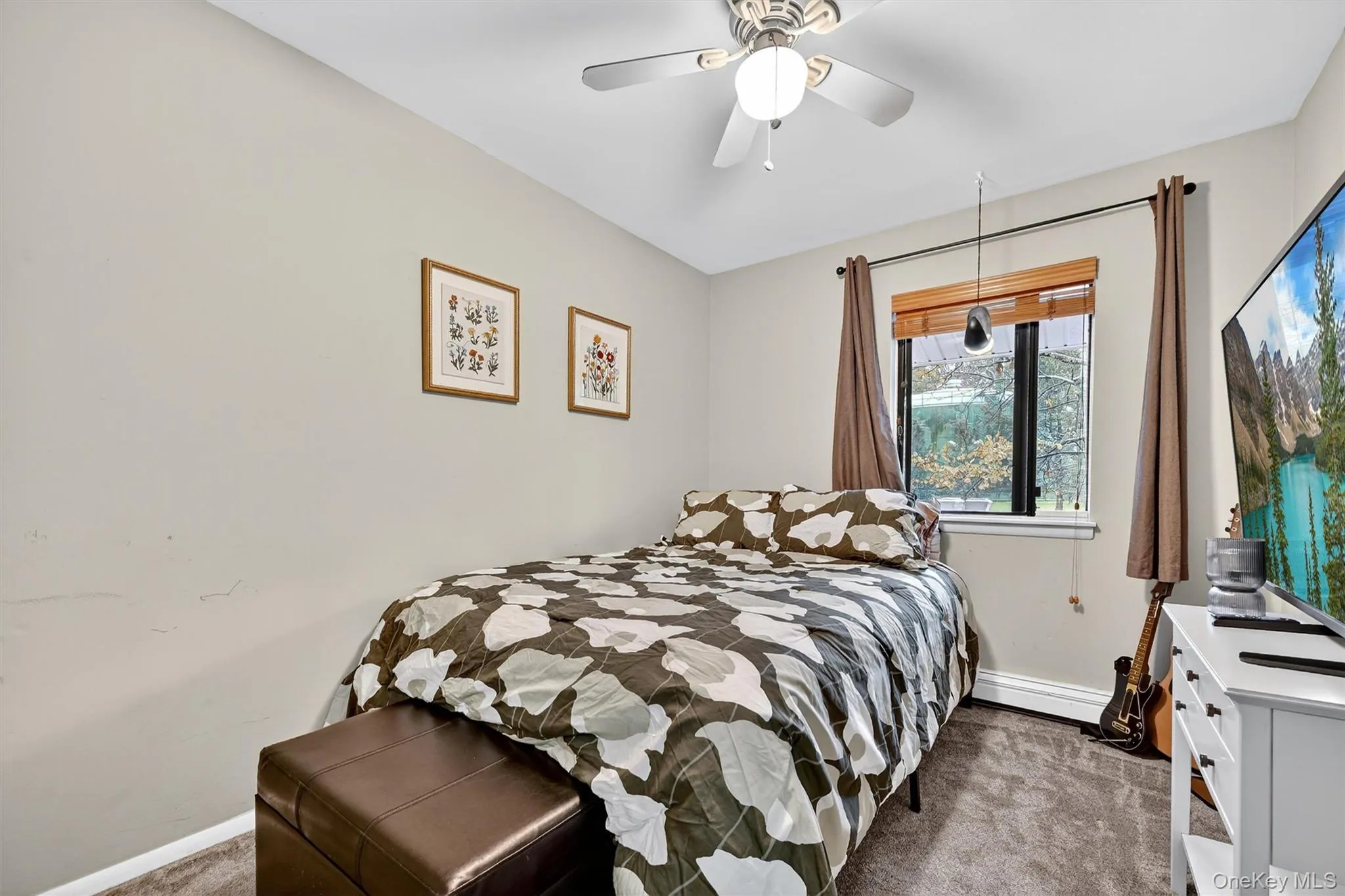 Carpeted bedroom with ceiling fan and a baseboard radiator Carpeted bedroom with ceiling fan and a baseboard radiator