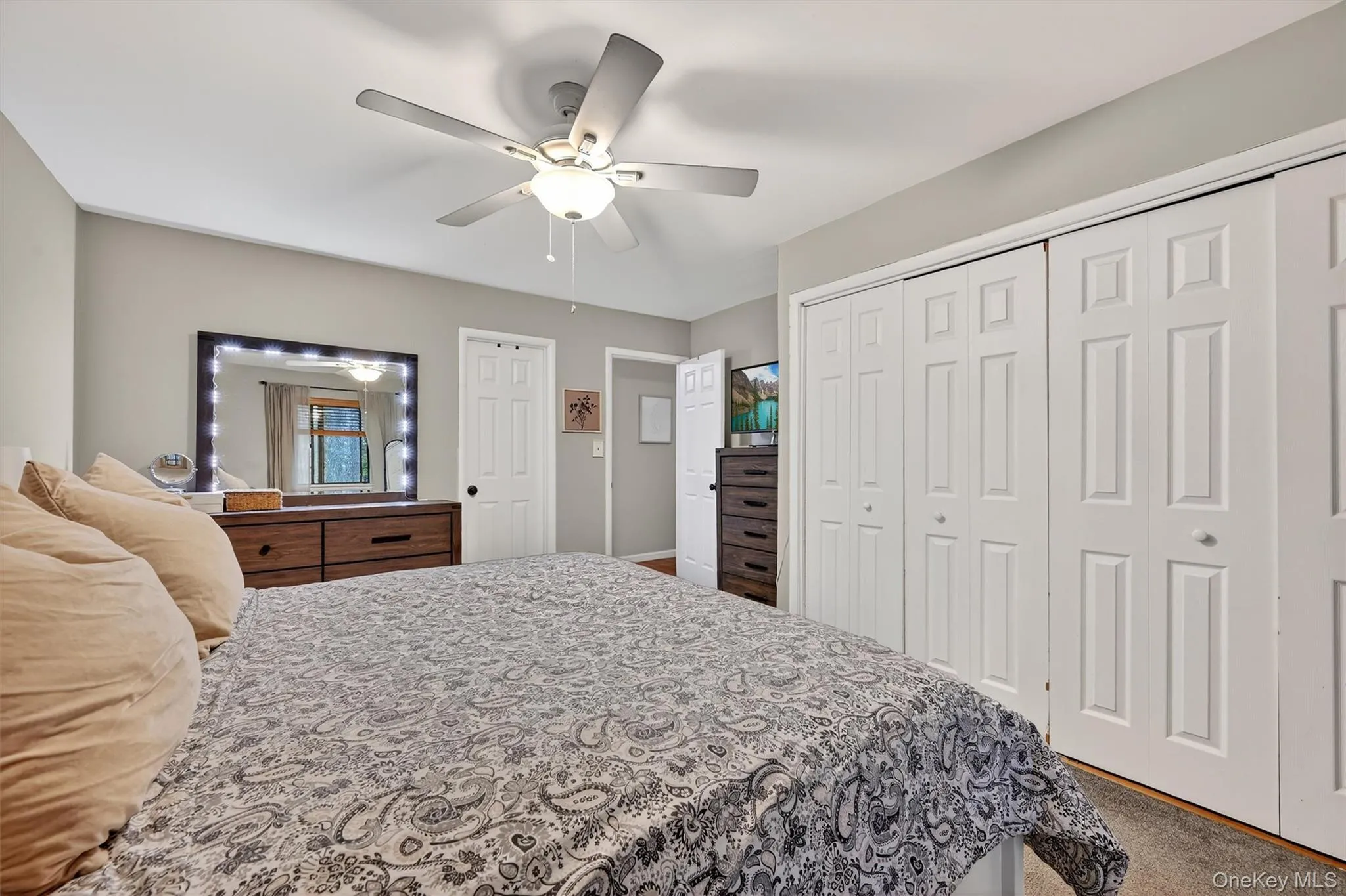 Bedroom featuring carpet, a ceiling fan, and a closet Bedroom featuring carpet, a ceiling fan, and a closet