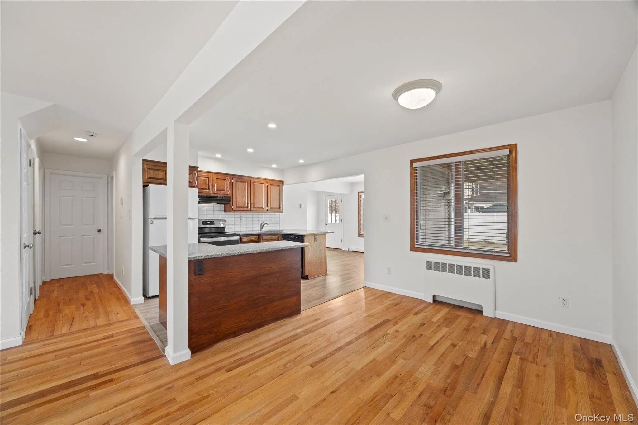 Hardwood flooring, white walls, and a window with blinds Hardwood flooring, white walls, and a window with blinds