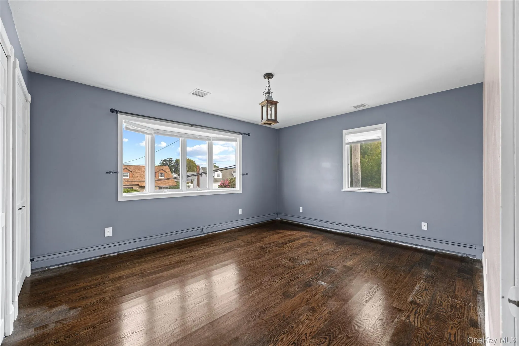 Dark wood-finish flooring with a prominent bay window Dark wood-finish flooring with a prominent bay window