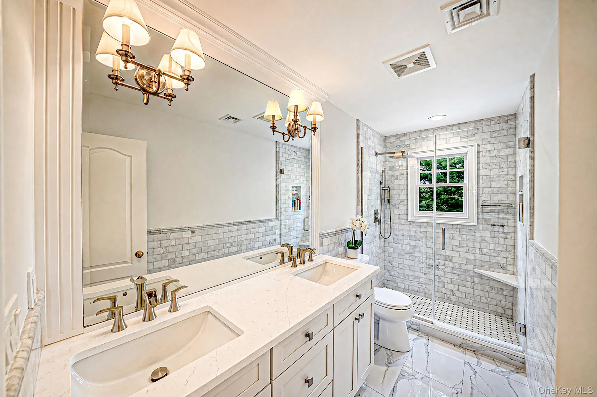 Dual vanity with integrated sinks and brushed brass fixtures Dual vanity with integrated sinks and brushed brass fixtures