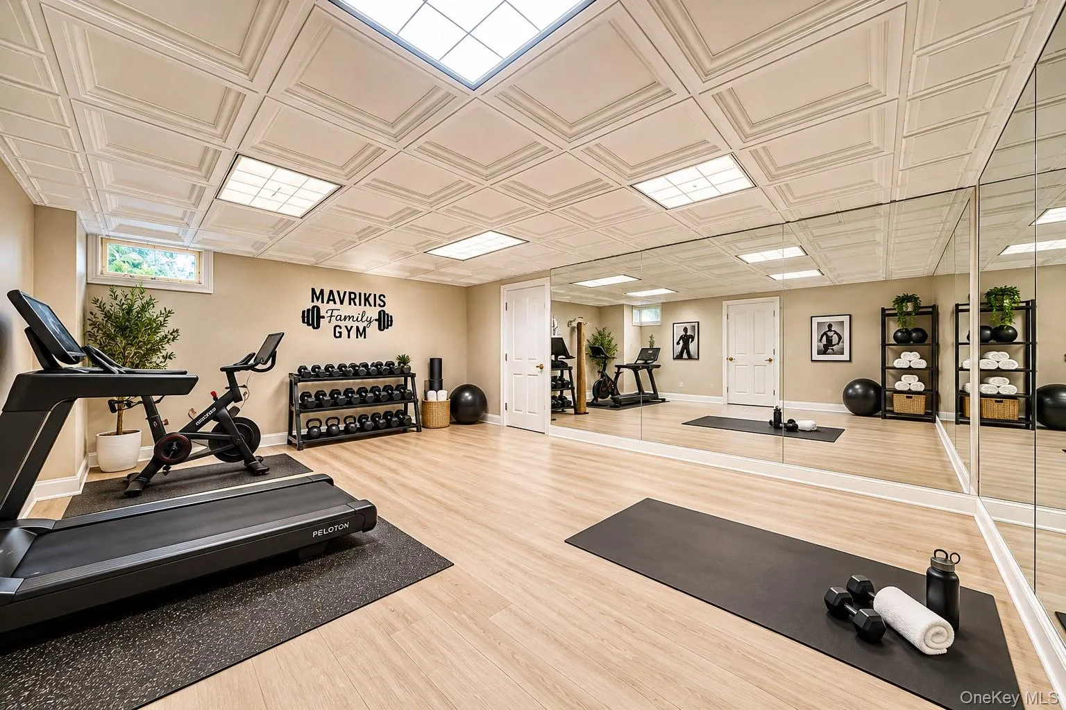 State-of-the-art home fitness studio featuring light wood-finish flooring, a full wall of mirrored panels, recessed and panel ceiling lighting, and a comprehensive selection of exercise equipment State-of-the-art home fitness studio featuring light wood-finish flooring, a full wall of mirrored panels, recessed and panel ceiling lighting, and a comprehensive selection of exercise equipment